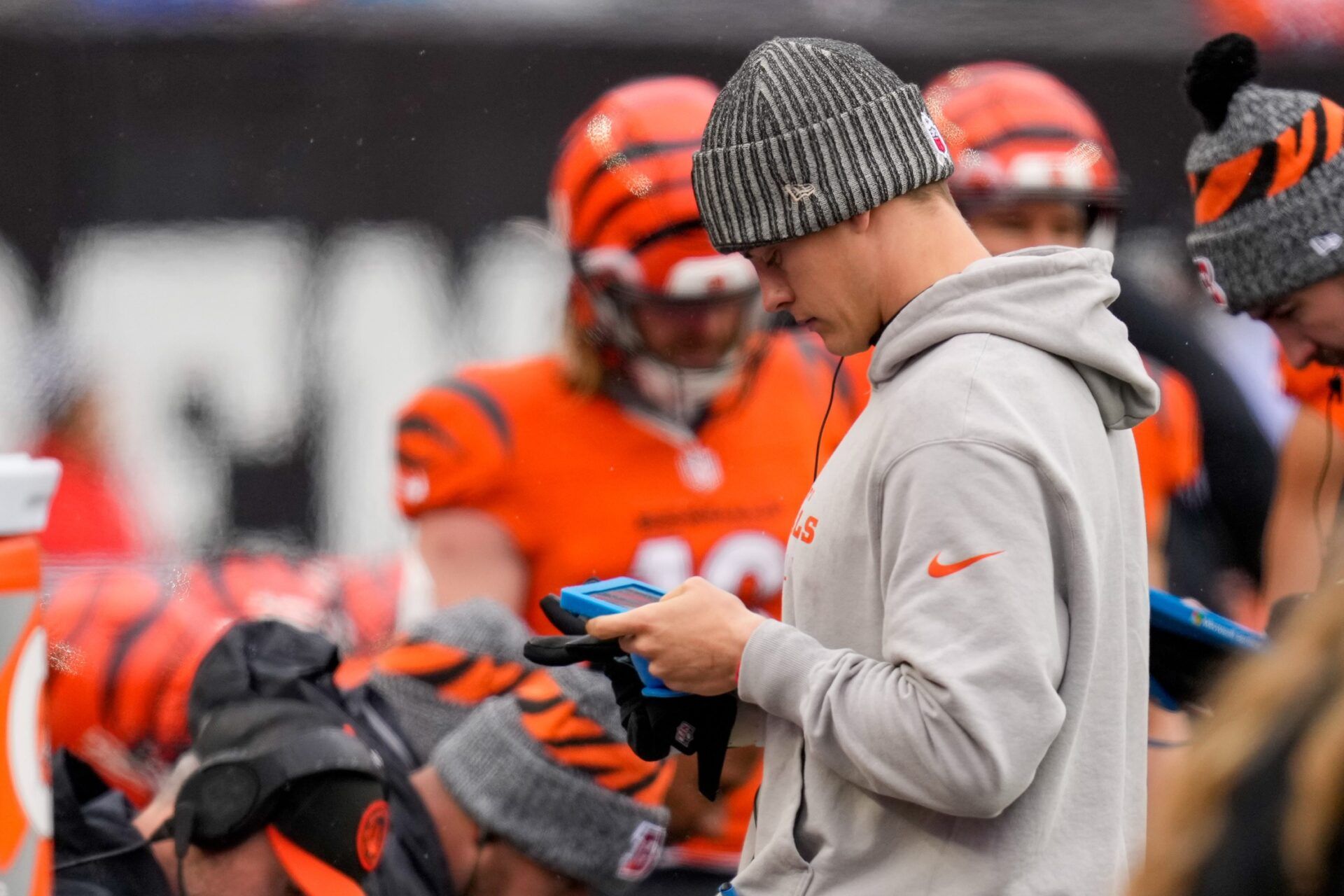 Injured Cincinnati Bengals quarterback Joe Burrow (9) views footage on a tablet in the first quarter.
