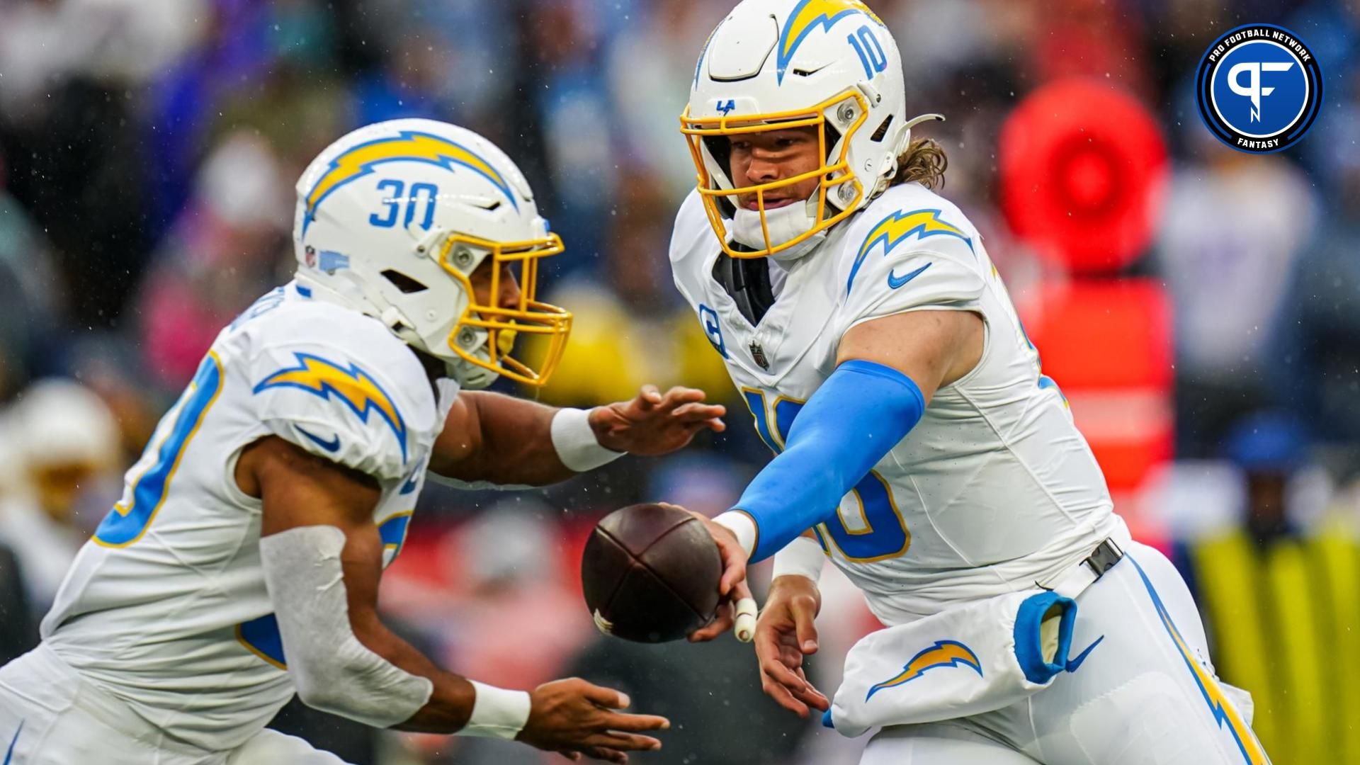 Los Angeles Chargers quarterback Justin Herbert (10) hands off the ball to running back Austin Ekeler (30) against the New England Patriots in the first quarter at Gillette Stadium.