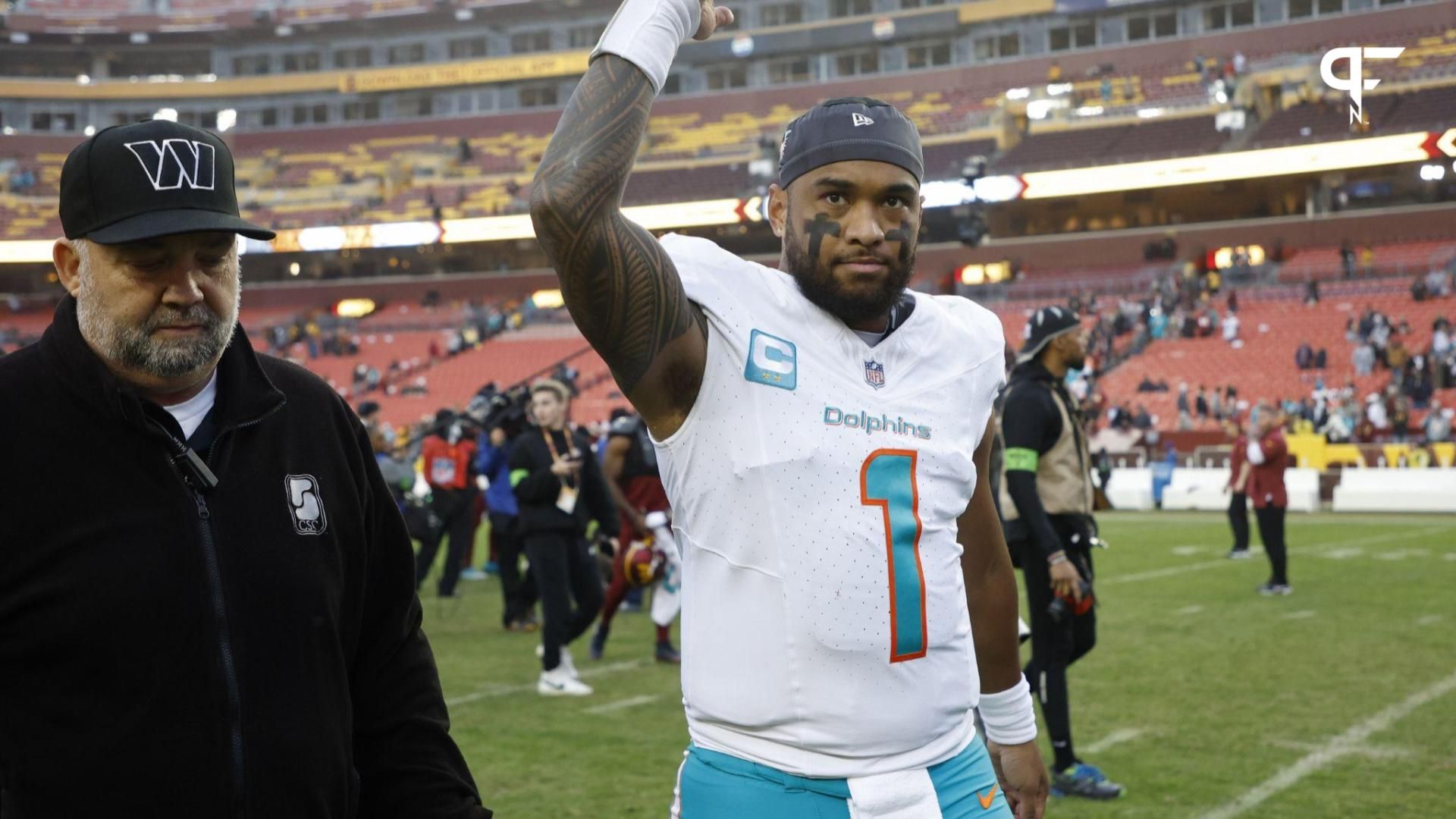 Miami Dolphins quarterback Tua Tagovailoa (1) waves to fans while leaving the field after the Dolphins' game against the Washington Commanders at FedExField.