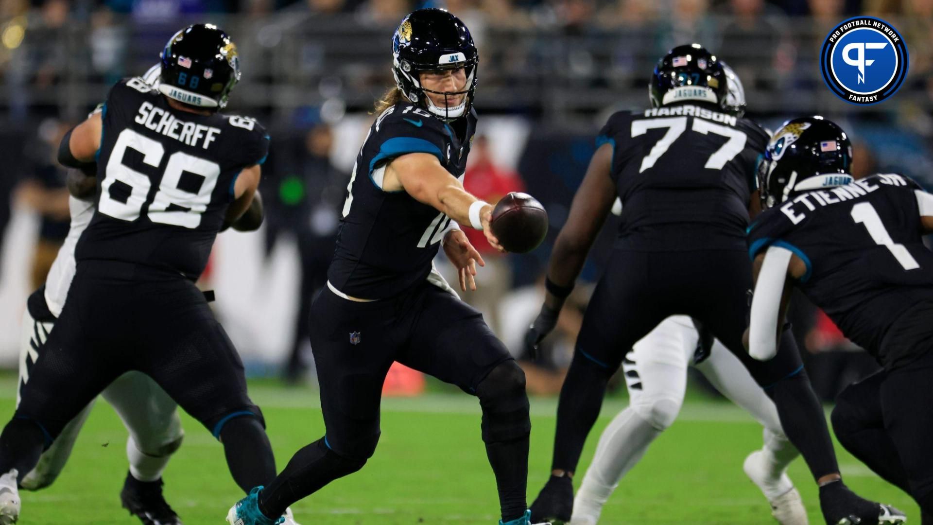 Jacksonville Jaguars quarterback Trevor Lawrence (16) hands off to running back Travis Etienne Jr. (1) during the third quarter.