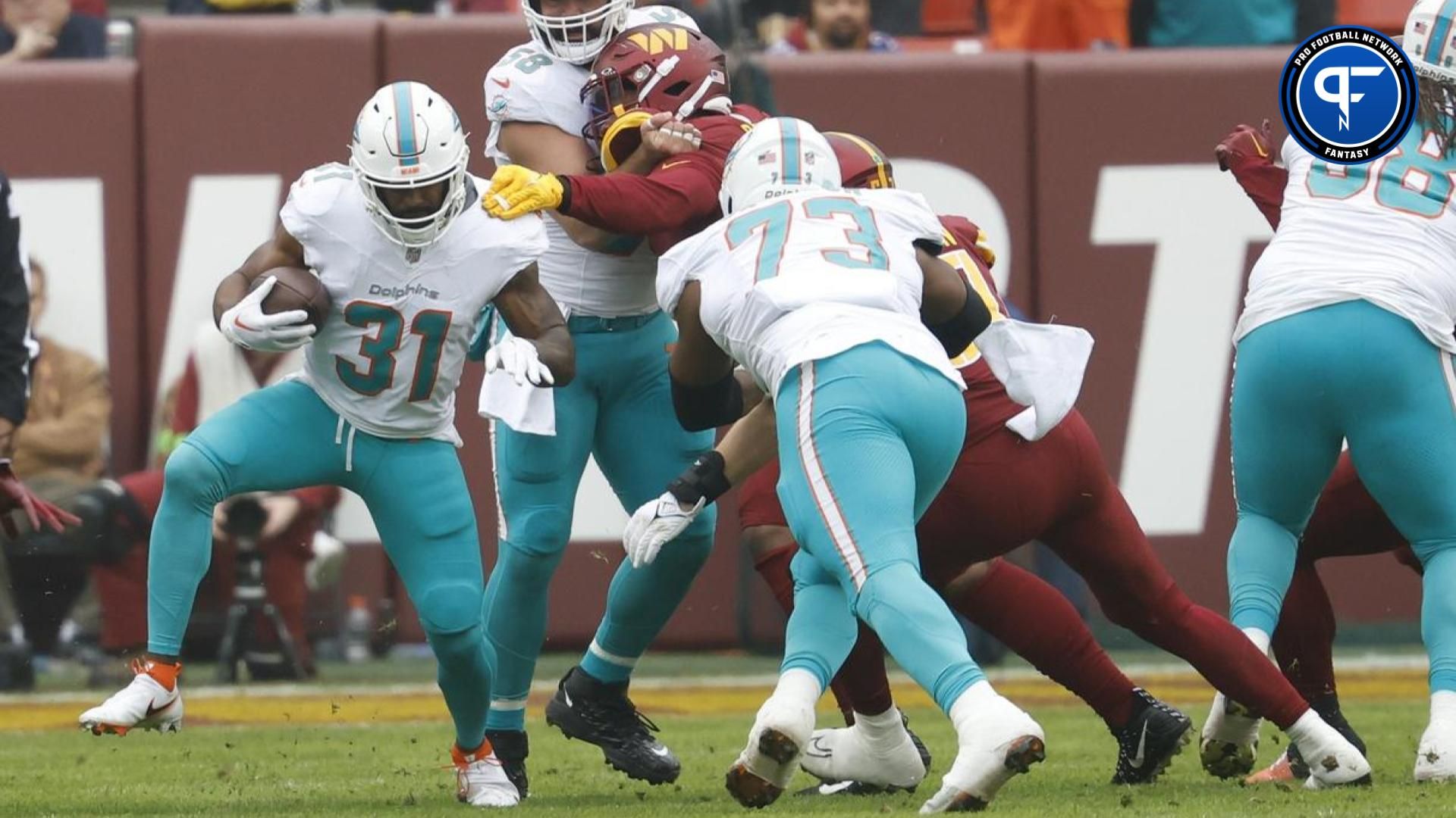 Miami Dolphins running back Raheem Mostert (31) carries the ball past Washington Commanders linebacker Cody Barton (57) during the first quarter at FedExField.