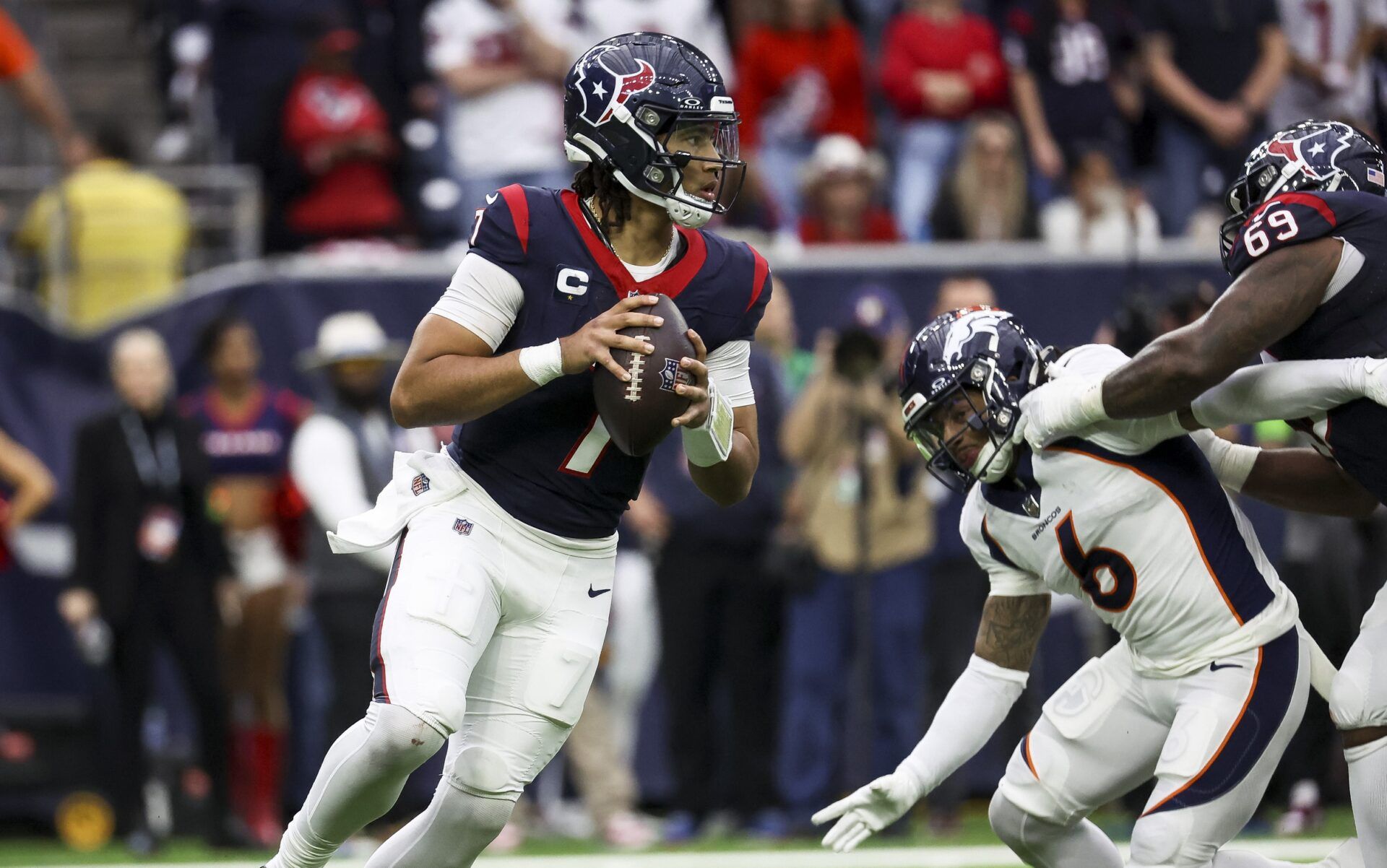 Houston Texans quarterback C.J. Stroud (7) rolls out of the pocket on a play during the fourth quarter against the Denver Broncos at NRG Stadium.