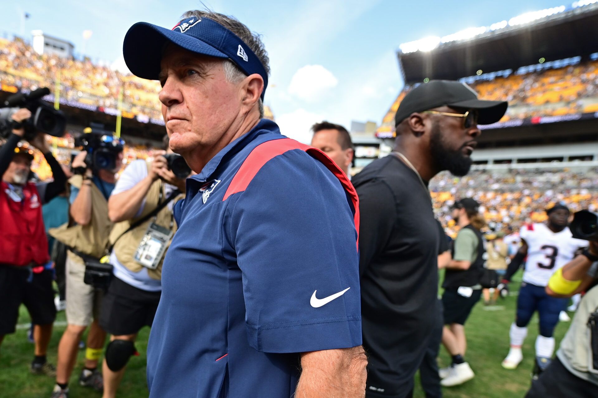 New England Patriots head coach Bill Belichick walks away from Pittsburgh Steelers head coach Mike Tomlin after shaking his hand after a game at Acrisure Stadium.