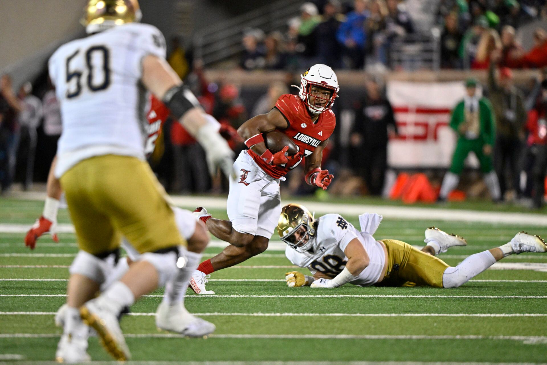 Louisville Cardinals defensive back Devin Neal (27) returns an interception past Notre Dame Fighting Irish tight end Mitchell Evans (88) during the second half at L&N Federal Credit Union Stadium.