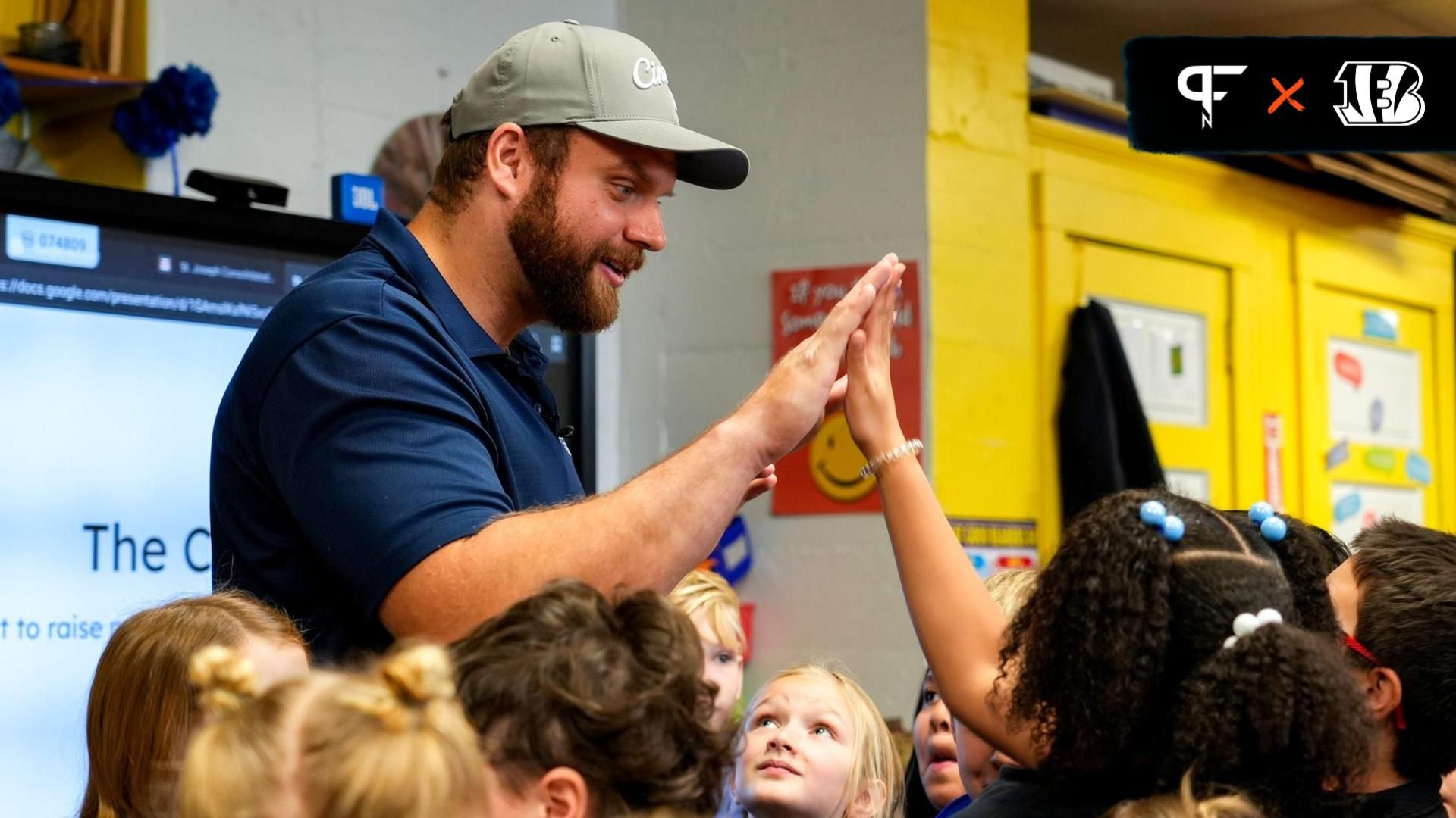 Cincinnati Bengals center Ted Karras (64) high fives a third grader on Tuesday, Nov. 28, 2023, at St. Joseph s Consolidated School in Hamilton, Ohio. Over a year ago Karras began selling The Cincy H...