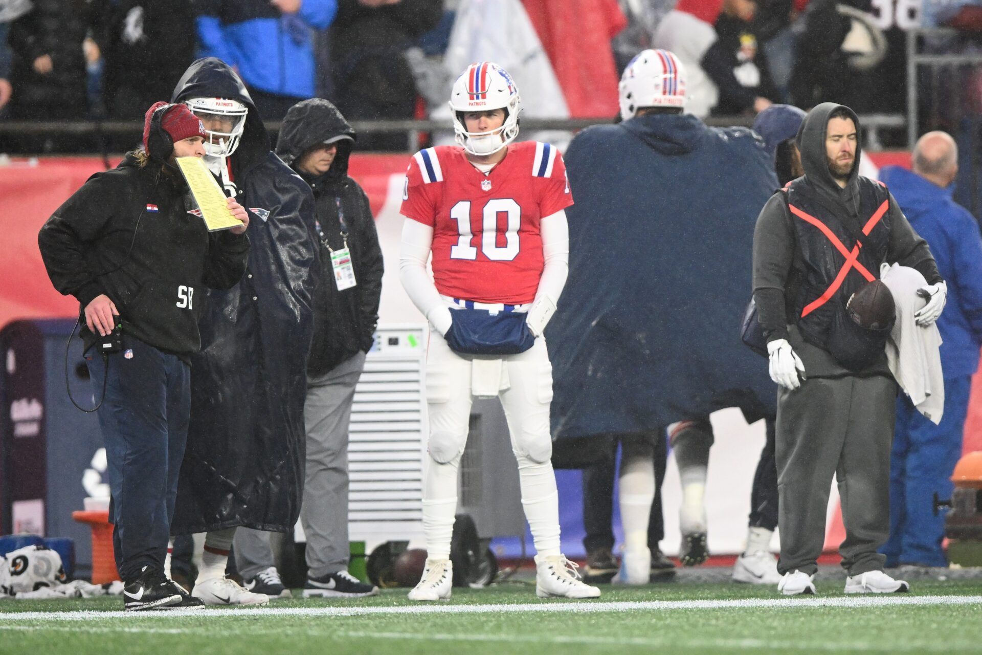 New England Patriots quarterback Mac Jones (10) watches a game against the Los Angeles Chargers from the sidelines during the second half at Gillette Stadium.