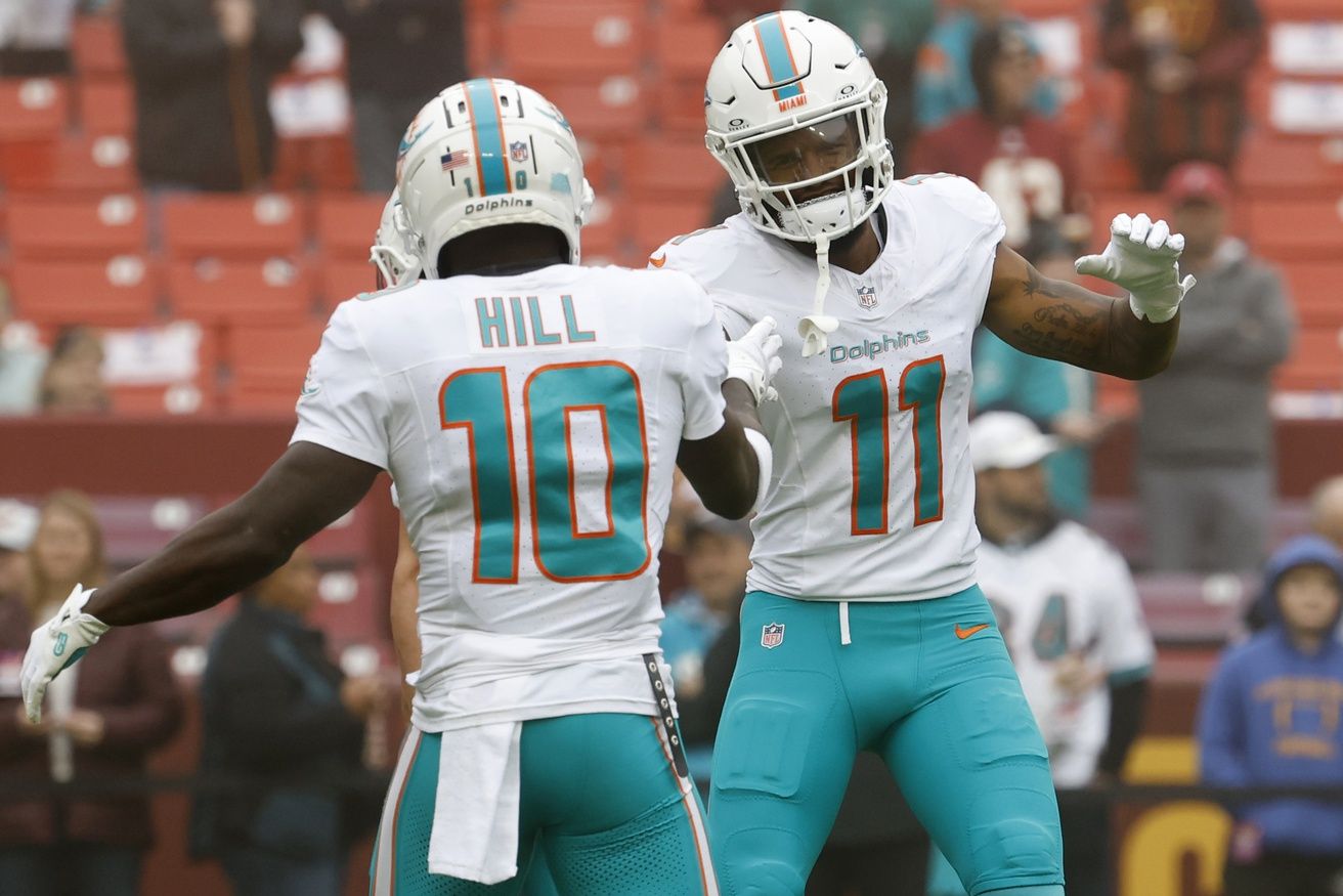 Miami Dolphins wide receiver Tyreek Hill (10) shakes hands with Dolphins wide receiver Cedrick Wilson Jr. (11) during warm up prior to the Dolphins' game against the Washington Commanders at FedExField