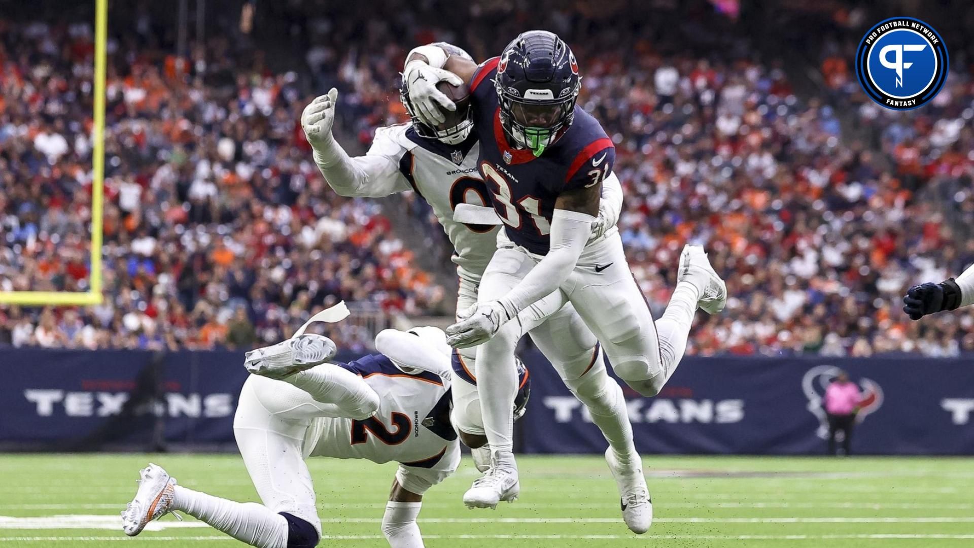 Houston Texans running back Dameon Pierce (31) runs with the ball as Denver Broncos linebacker Jonathon Cooper (0) attempts to make a tackle during the fourth quarter at NRG Stadium.