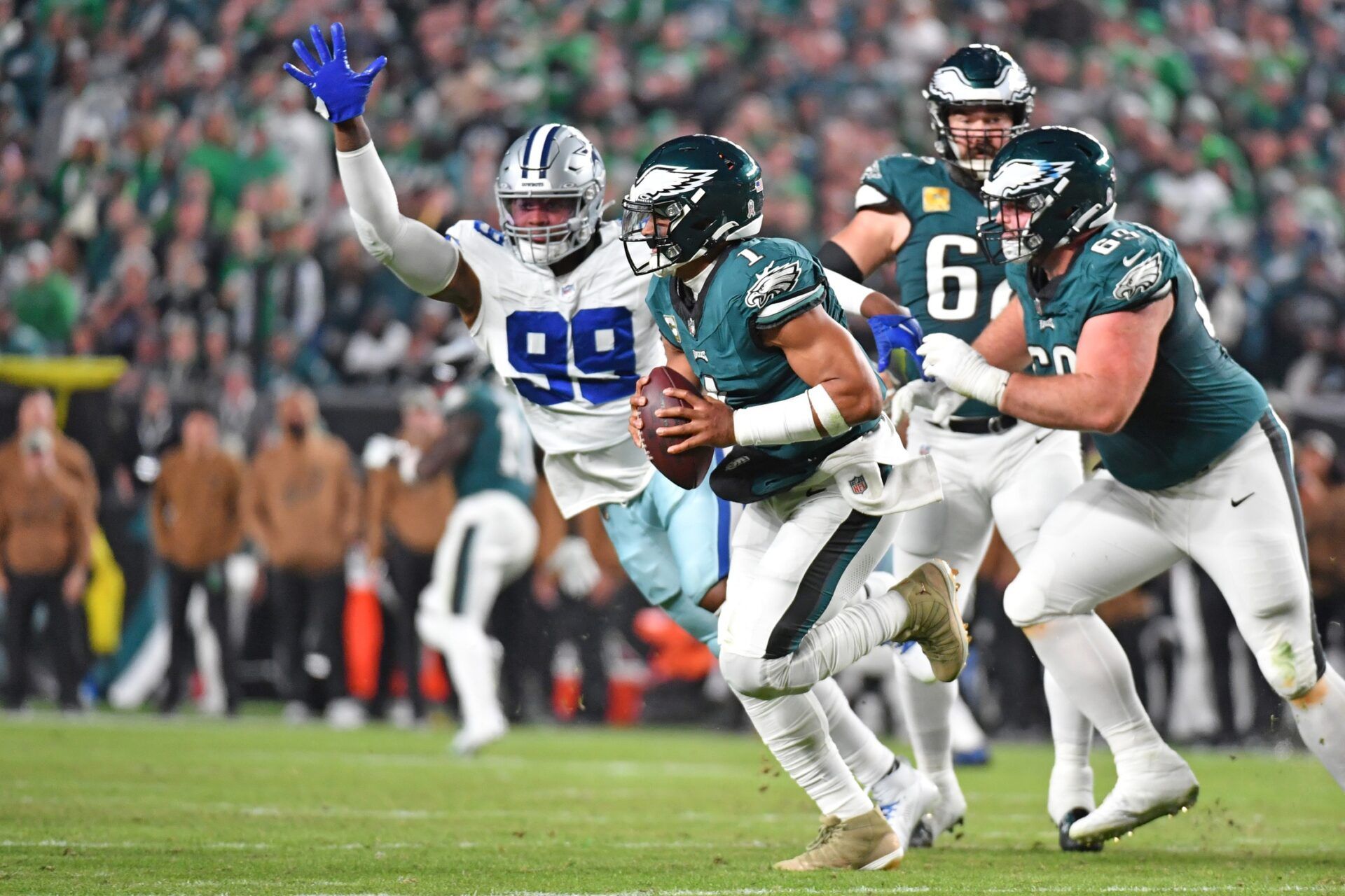 Philadelphia Eagles QB Jalen Hurts (1) scrambles away from Dallas Cowboys defenders.