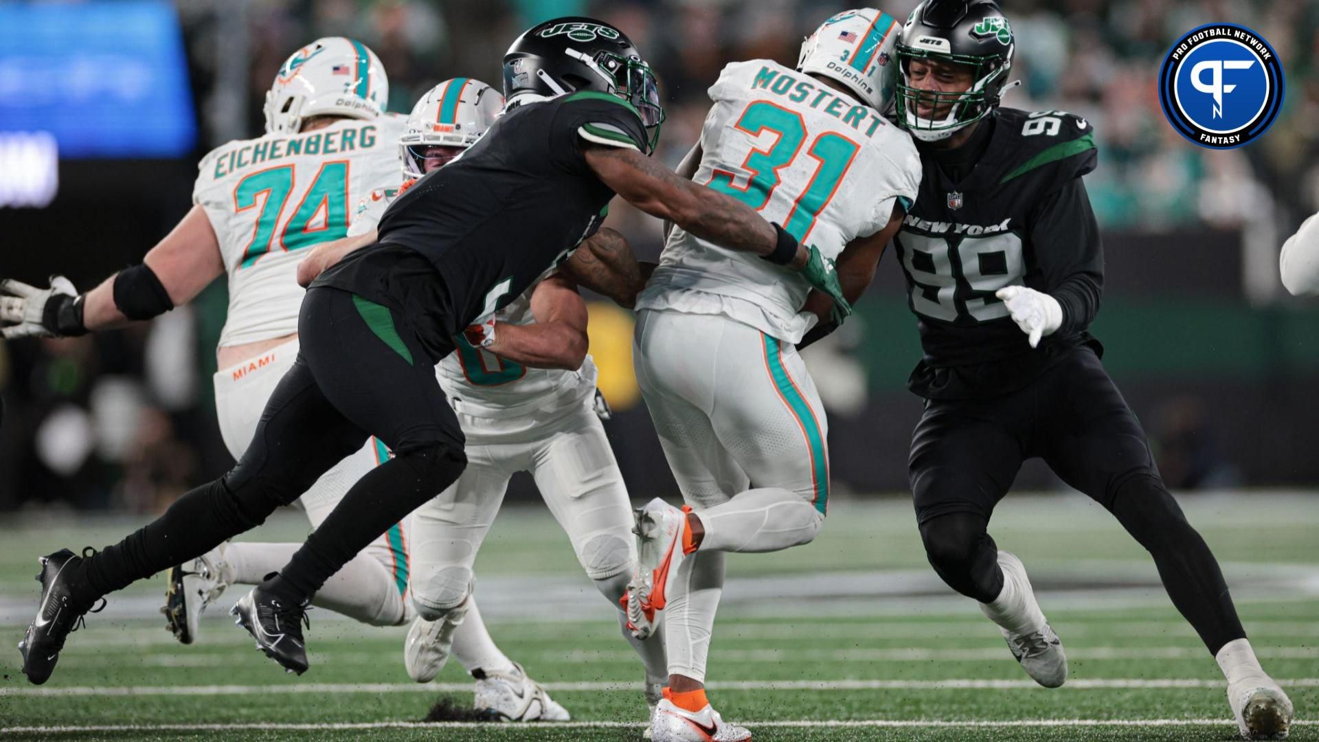 Miami Dolphins RB Raheem Mostert (31) gets tackled by a pair of New York Jets defenders.