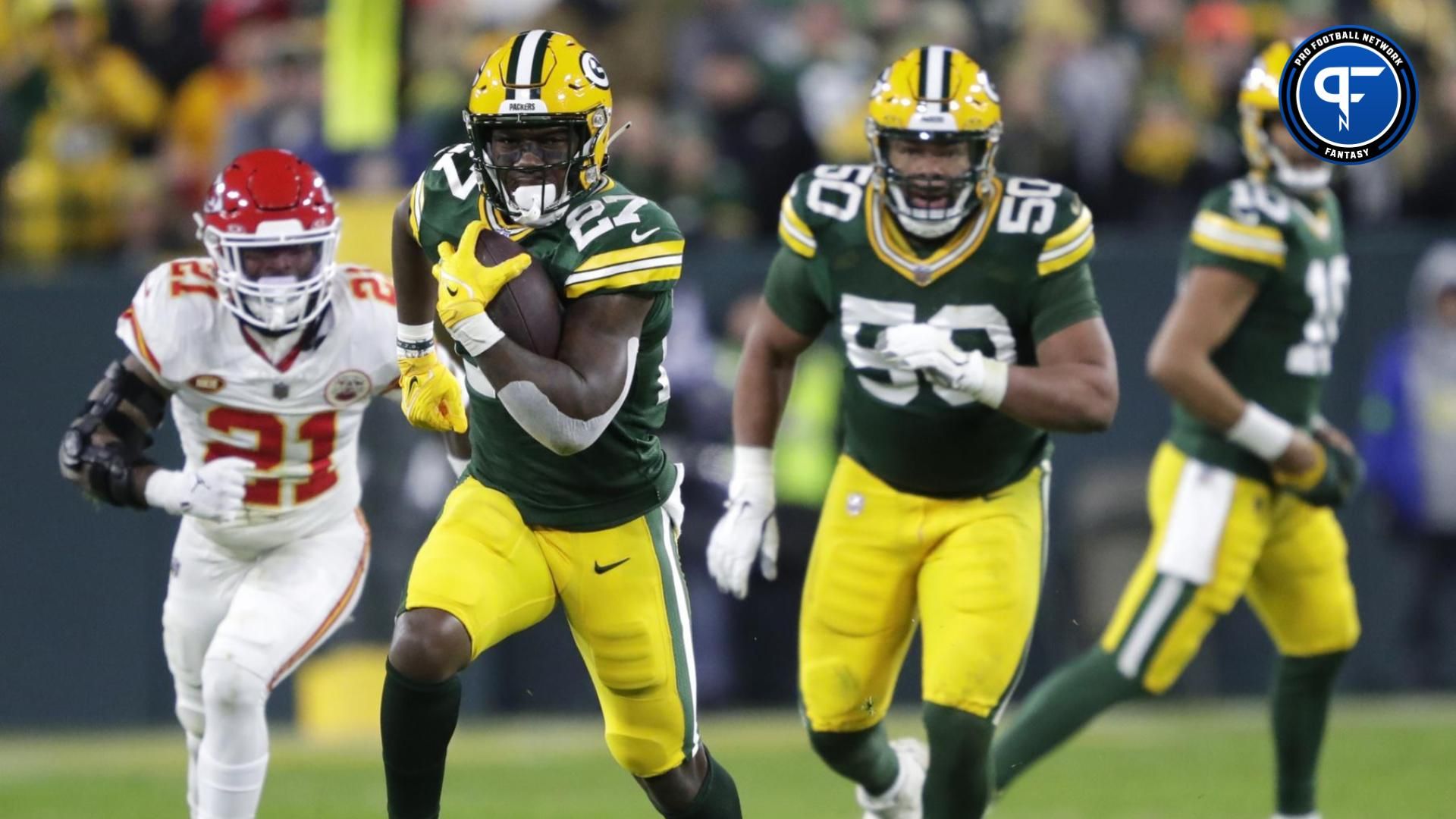 Green Bay Packers running back Patrick Taylor (27) breaks away from Kansas City Chiefs safety Mike Edwards (21) for a first down during their football game at Lambeau Field.