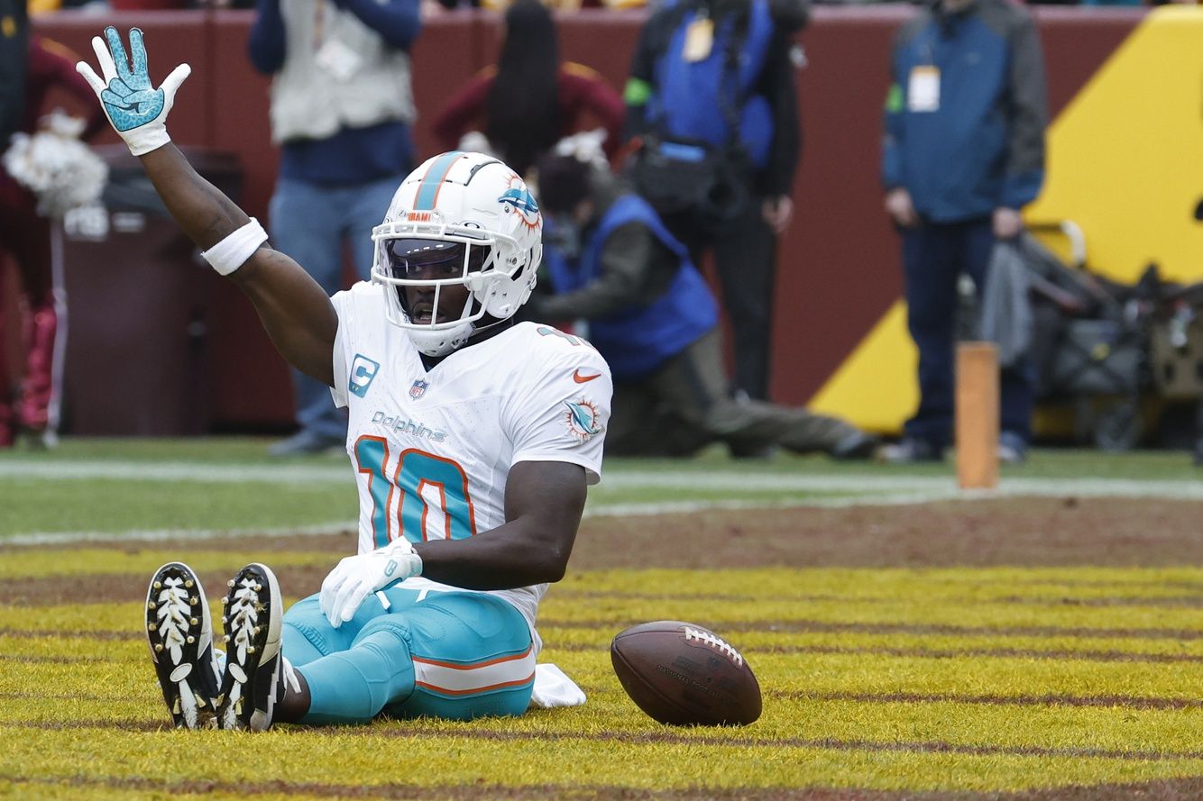 Miami Dolphins wide receiver Tyreek Hill (10) celebrates in the end zone after catching a touchdown pass against the Washington Commanders during the first quarter at FedExField.