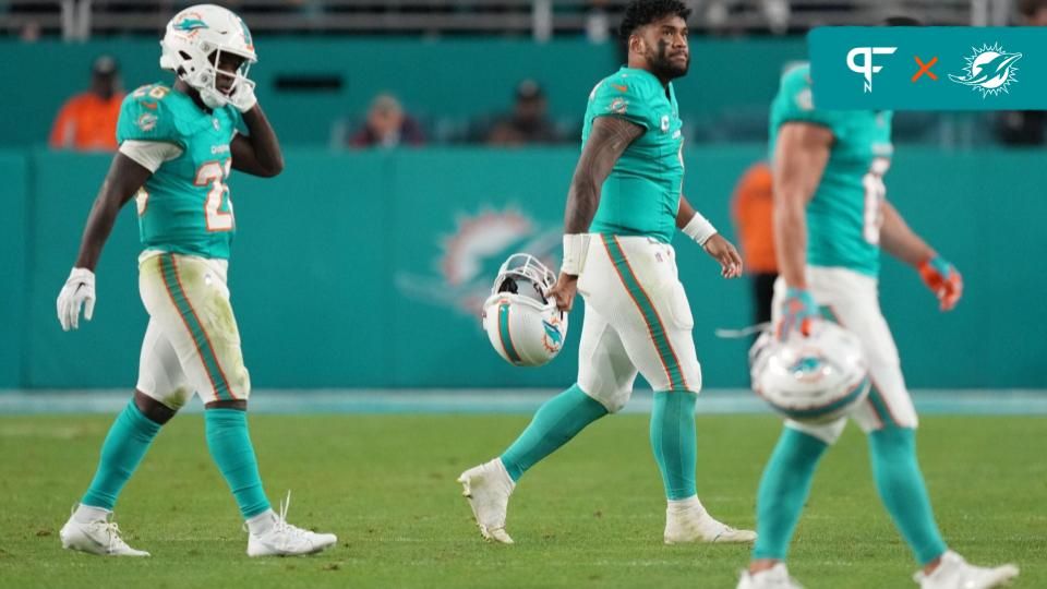 Miami Dolphins players walk off the field after an unsuccessful fourth-down try.