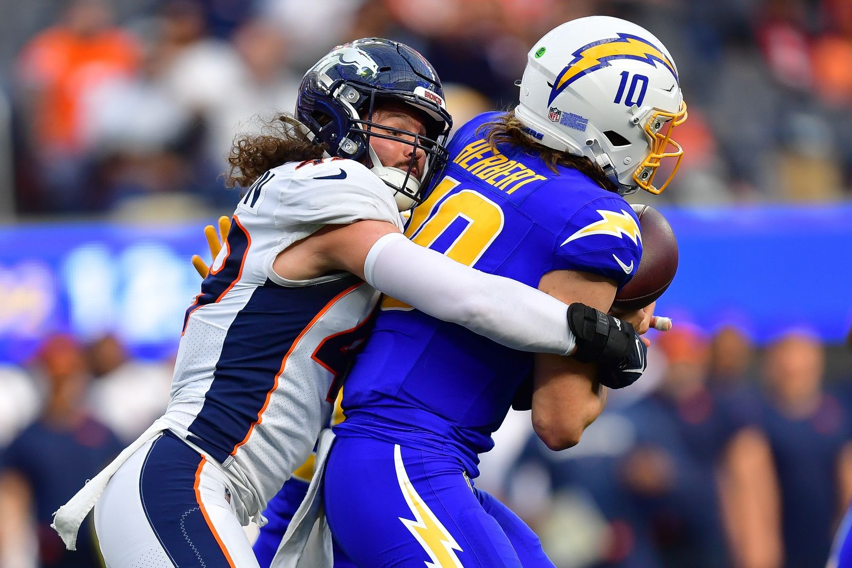 Denver Broncos LB Alex Singleton (49) brings down Los Angeles Chargers QB Justin Herbert (10).