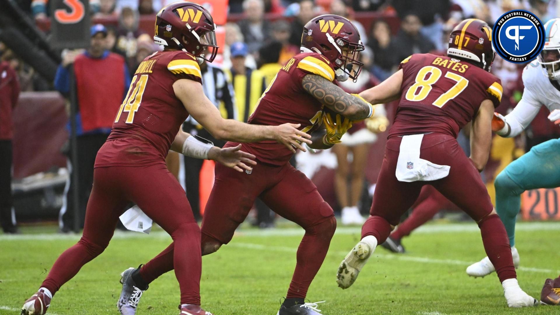 Washington Commanders running back Brian Robinson Jr. (8) receives the handoff from quarterback Sam Howell (14) against the Miami Dolphins during the second half at FedExField.