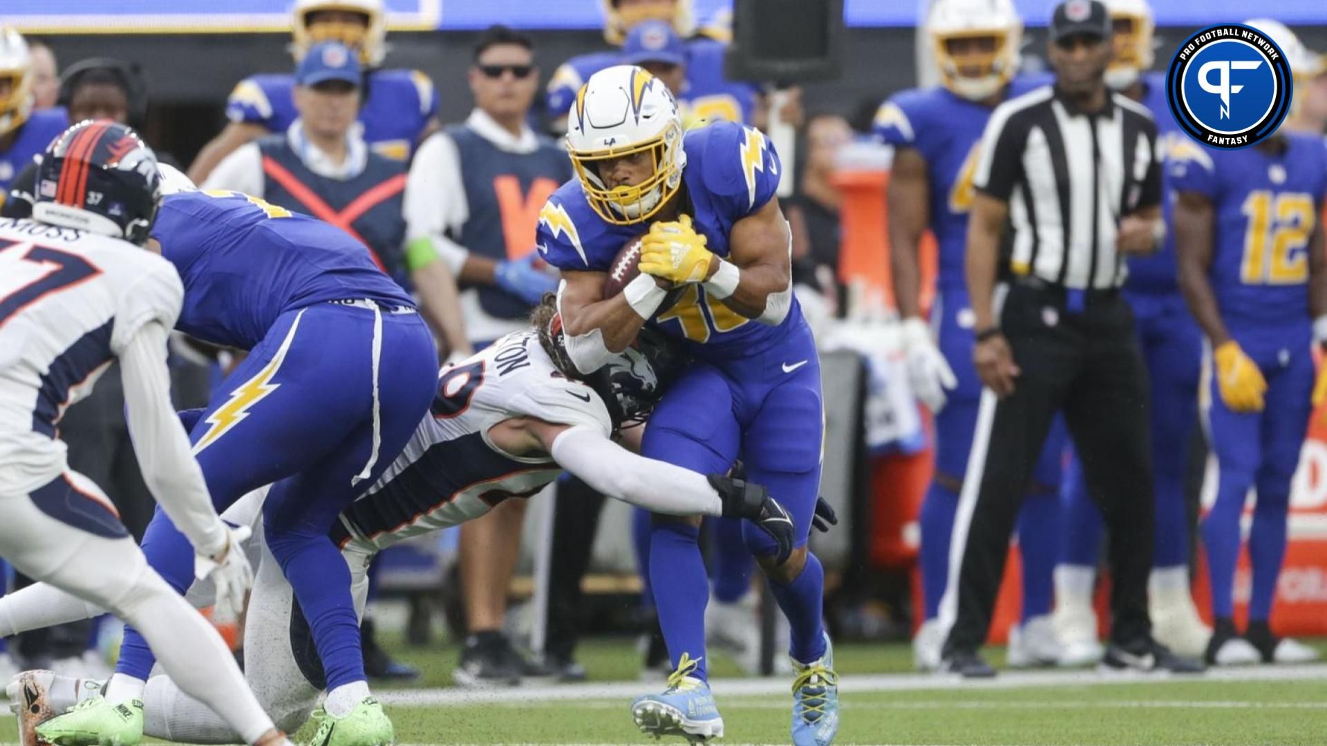 Los Angeles Chargers running back Austin Ekeler (30) is tackled by Denver Broncos running back Dwayne Washington (39) during the first half at SoFi Stadium.