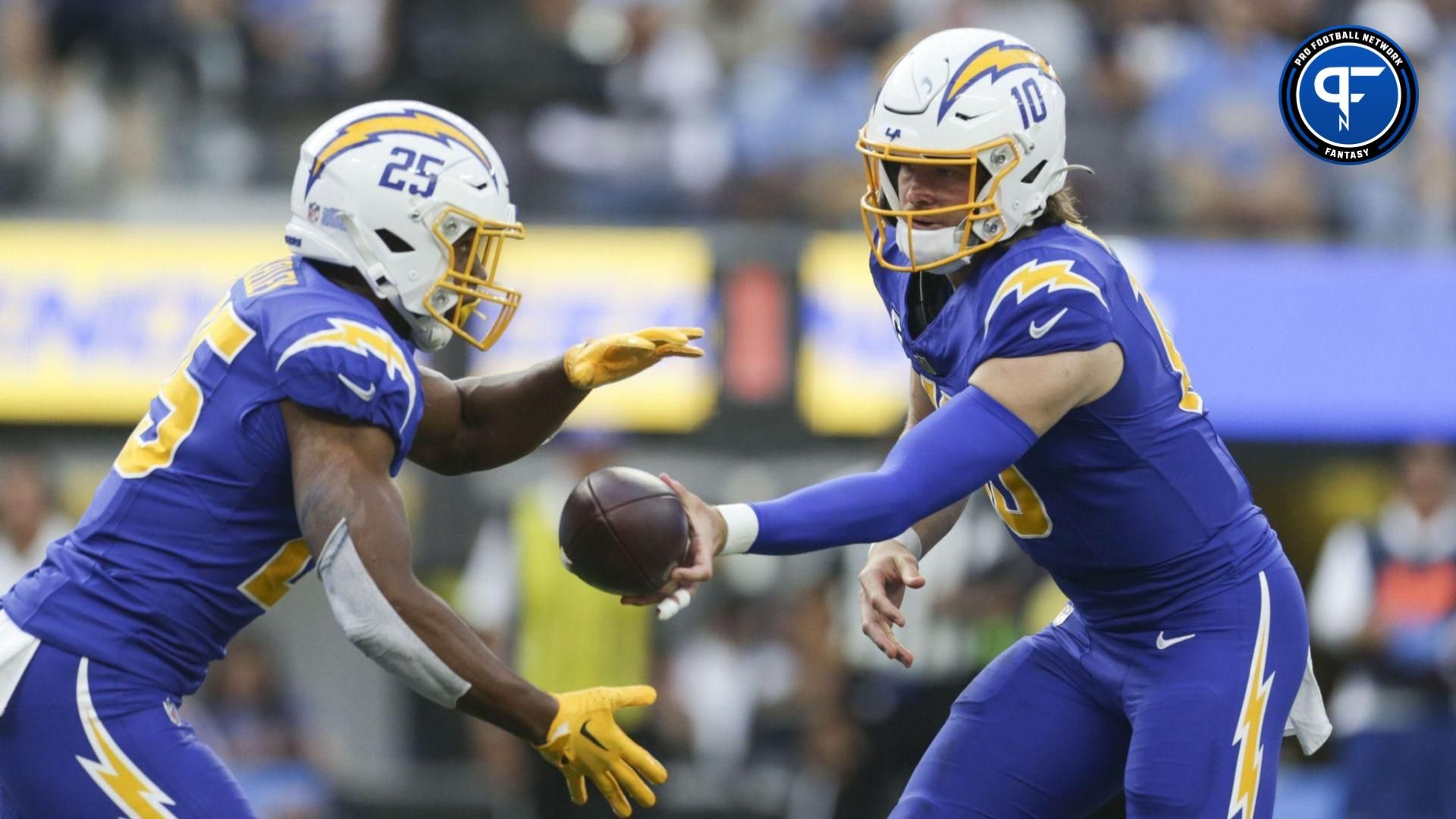 Los Angeles Chargers quarterback Justin Herbert (10) hands the ball to Los Angeles Chargers running back Joshua Kelley (25) during the first half in a game against the Denver Broncos at SoFi Stadium.