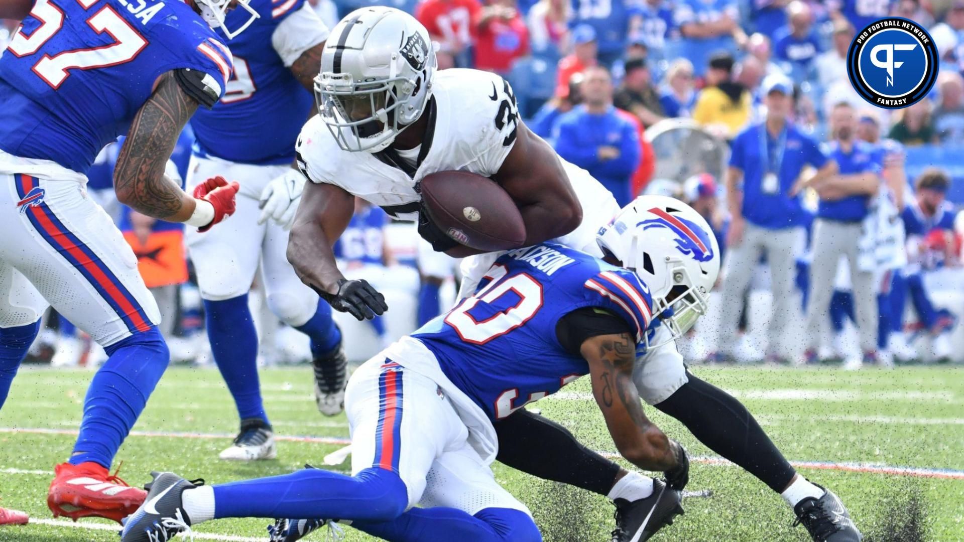 Las Vegas Raiders running back Zamir White (35) fumbles the ball on a tackle by Buffalo Bills cornerback Dane Jackson (30) in the fourth quarter at Highmark Stadium.