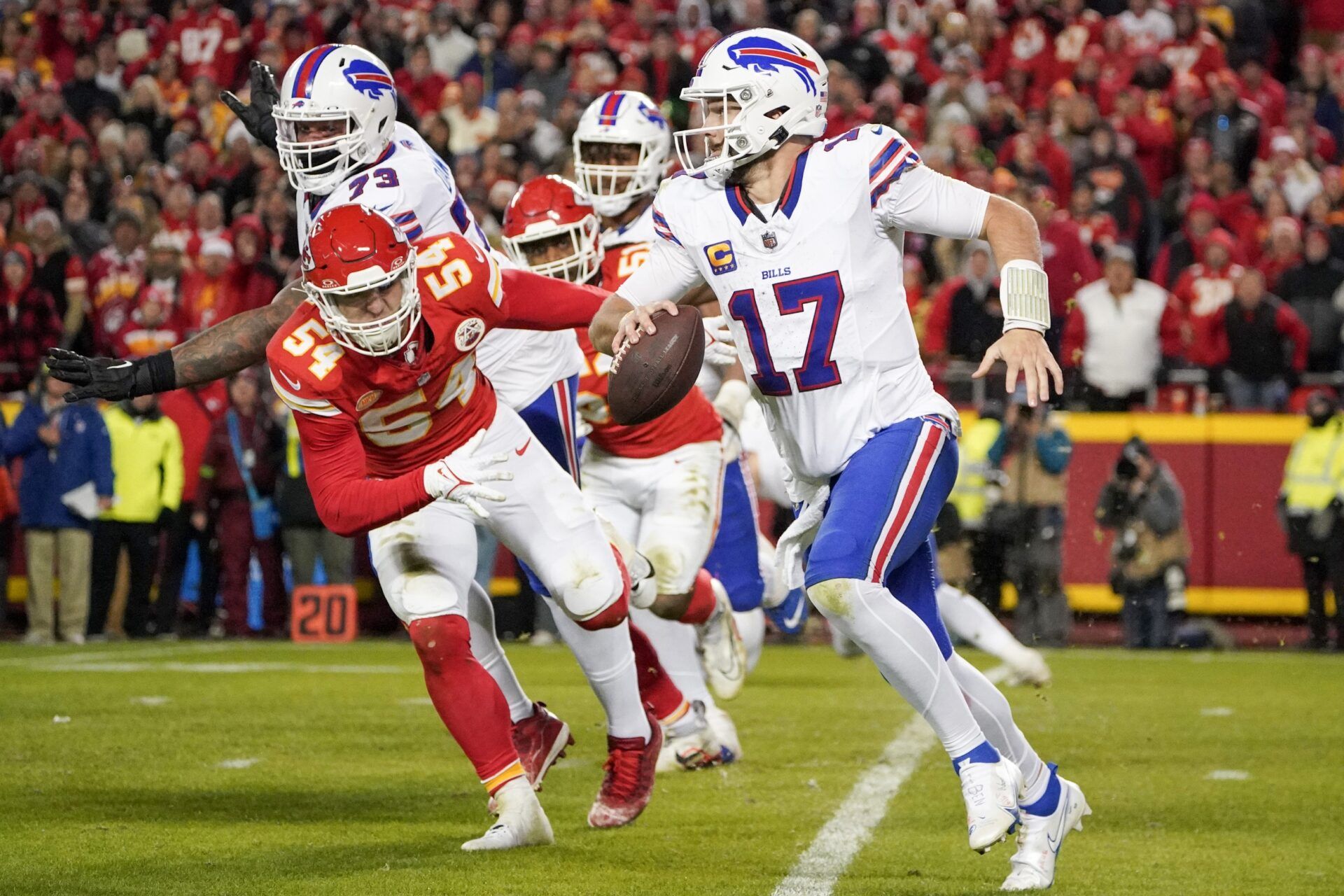 Buffalo Bills quarterback Josh Allen (17) scrambles as Kansas City Chiefs linebacker Leo Chenal (54) attempts the tackle during the second half at GEHA Field at Arrowhead Stadium.