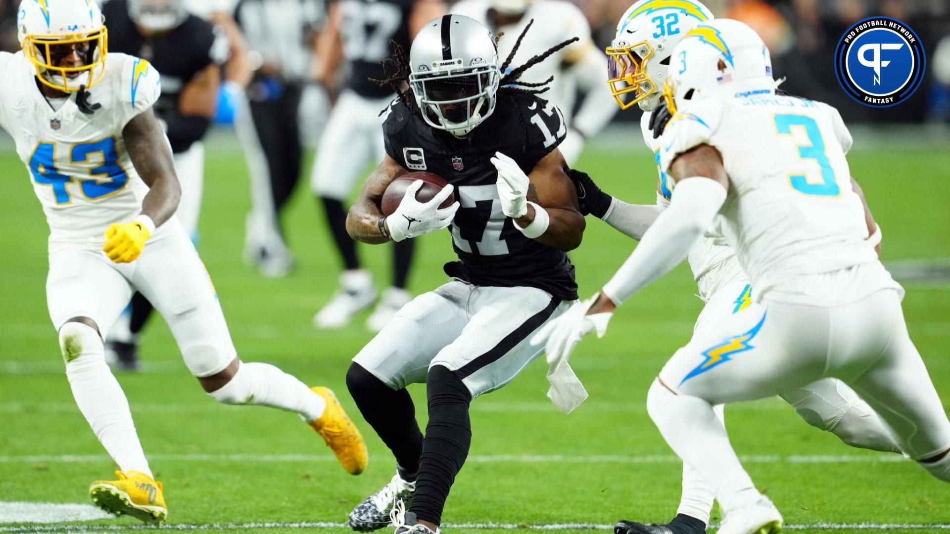 Las Vegas Raiders wide receiver Davante Adams (17) runs against Los Angeles Chargers safety Alohi Gilman (32) and safety Derwin James Jr. (3) in the first quarter at Allegiant Stadium.