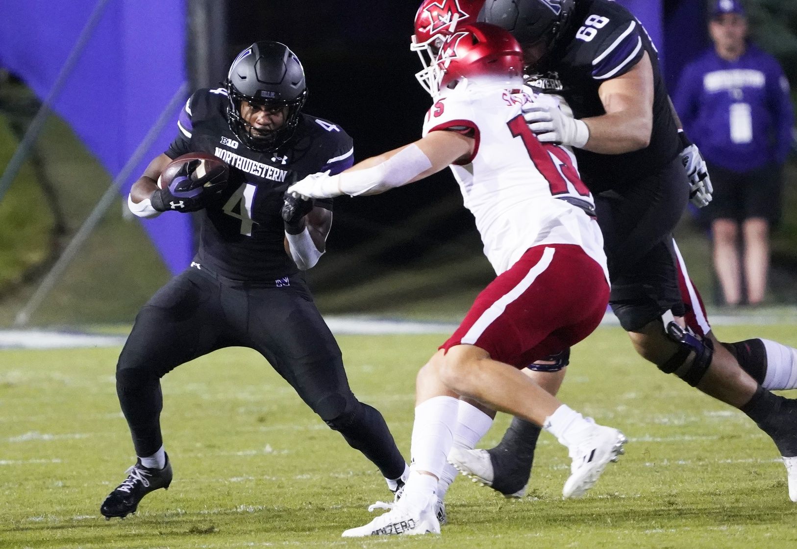 Miami RedHawks DB Matt Salopek (15) looks to tackle Northwestern RB Cam Porter (4).