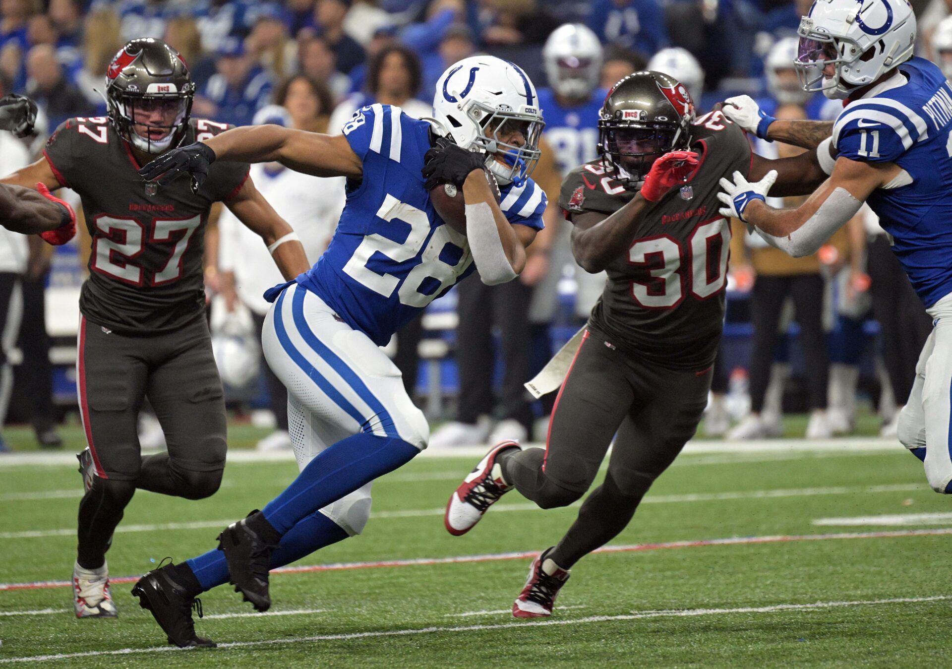 Indianapolis Colts running back Jonathan Taylor (28) runs to get past Tampa Bay Buccaneers cornerback Dee Delaney (30) during the second quarter at Lucas Oil Stadium.