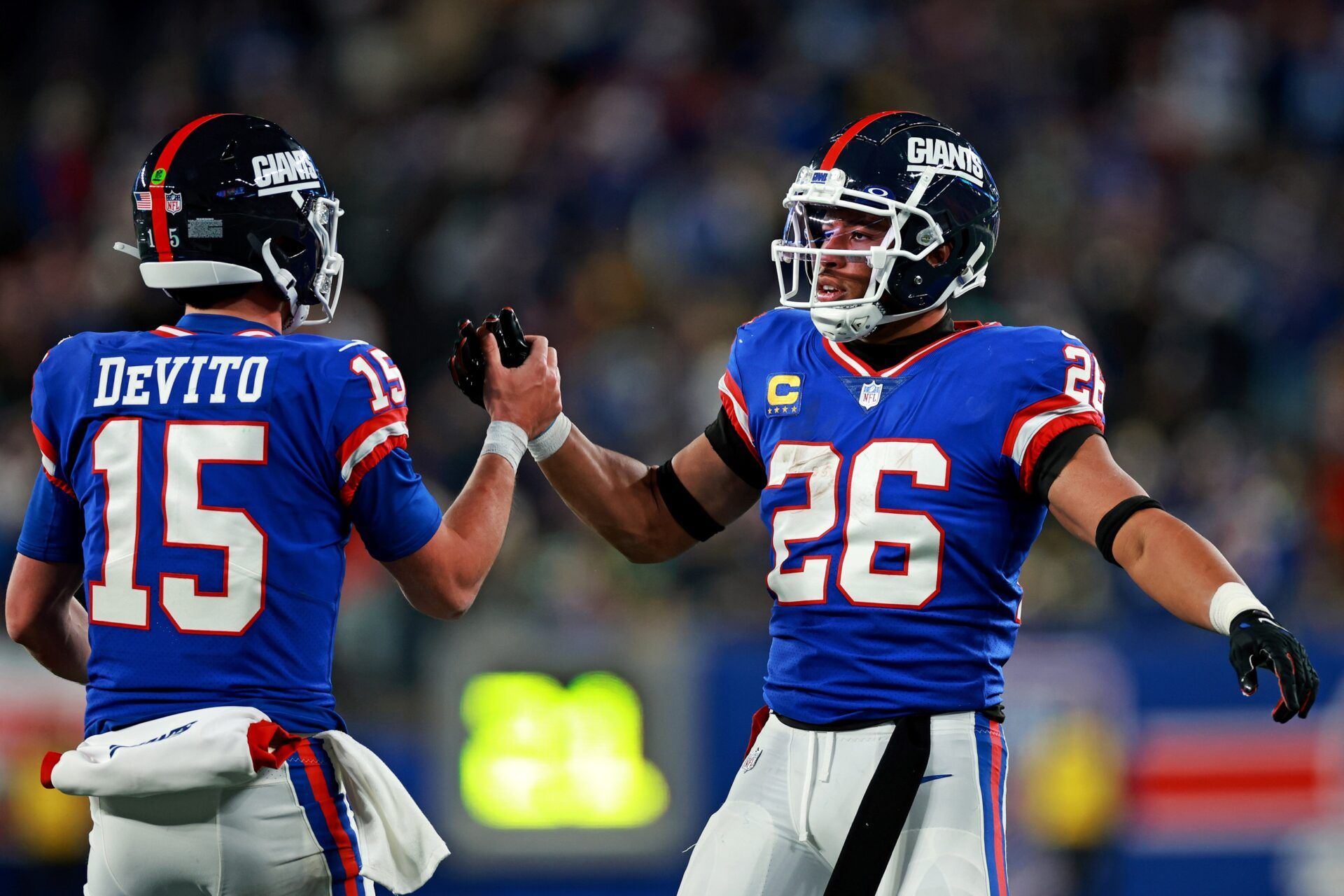 New York Giants running back Saquon Barkley (26) celebrates with quarterback Tommy DeVito (15) after scoring a touchdown during the third quarter against the Green Bay Packers at MetLife Stadium.
