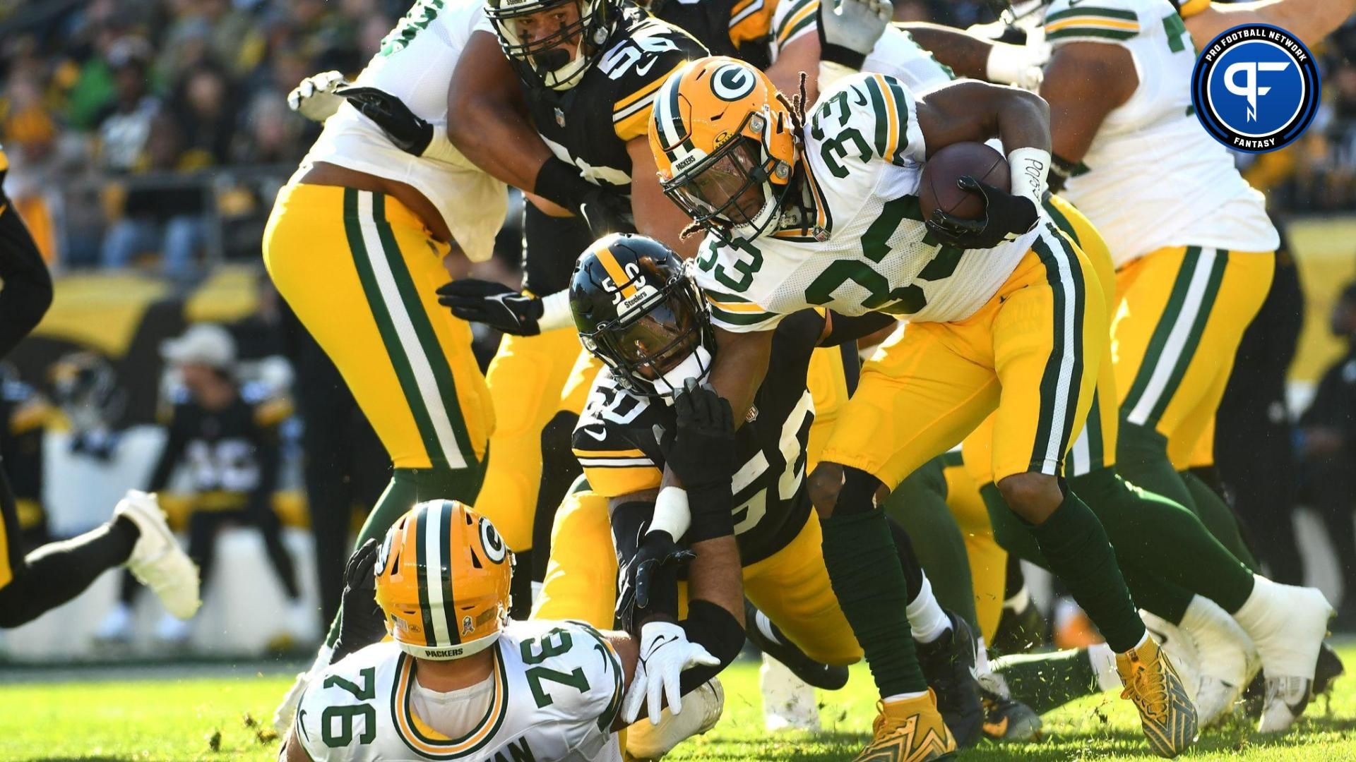 Green Bay Packers running back Aaron Jones (33) is slowed by Pittsburgh Steelers linebacker Elandon Roberts (50) during the first quarter at Acrisure Stadium.