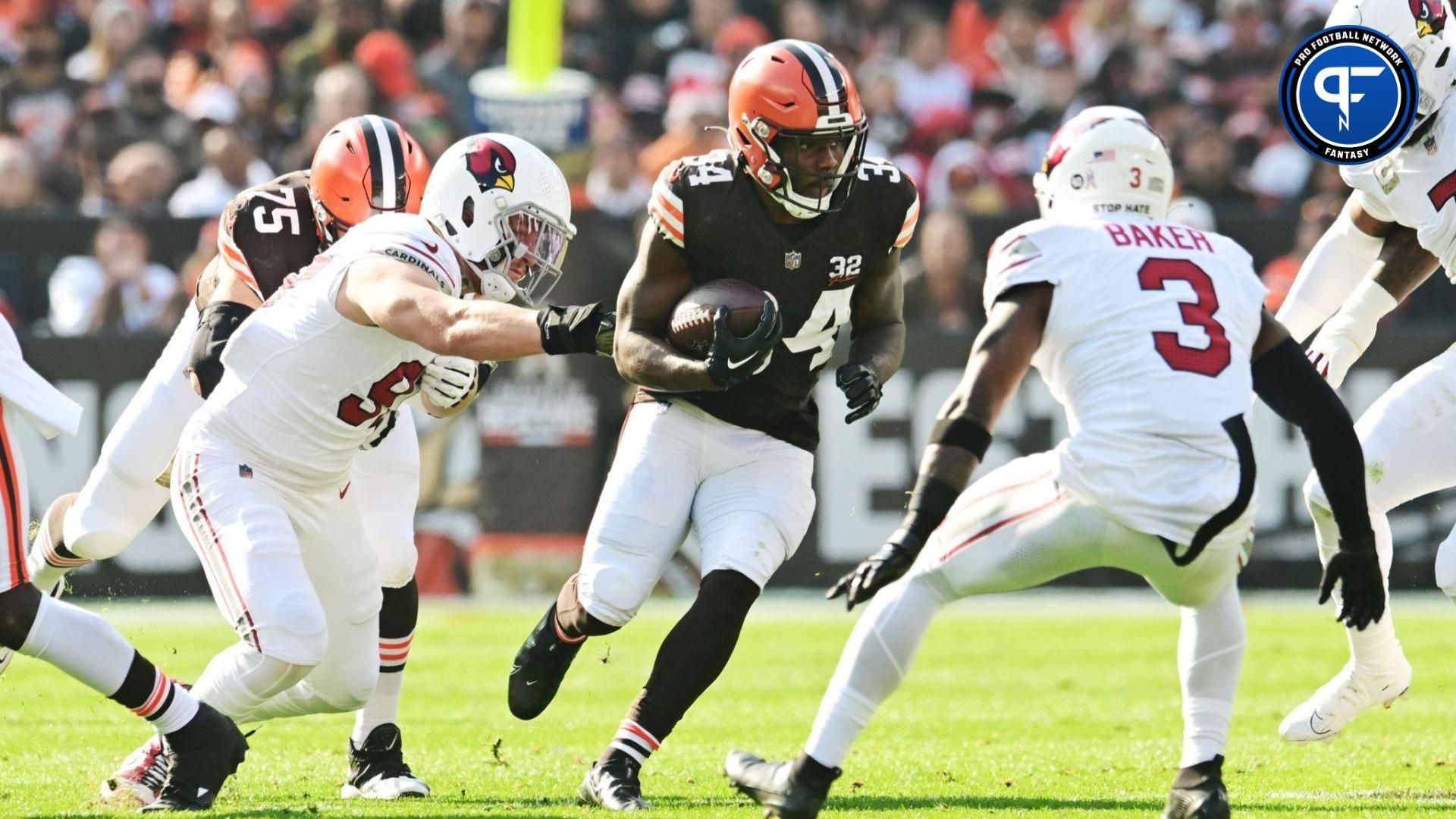 Cleveland Browns running back Jerome Ford (34) runs with the ball against Arizona Cardinals linebacker Cameron Thomas (97) and safety Budda Baker (3) during the first quarter at Cleveland Browns Stadium.