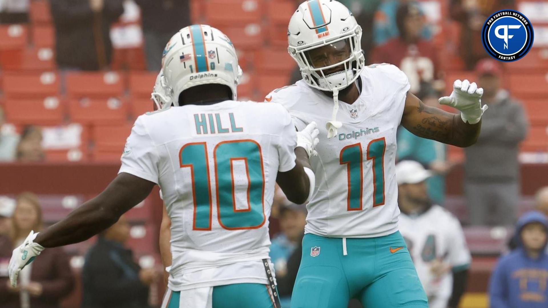 Miami Dolphins wide receiver Tyreek Hill (10) shakes hands with Dolphins wide receiver Cedrick Wilson Jr. (11) during warm up prior to the Dolphins' game against the Washington Commanders at FedExField.