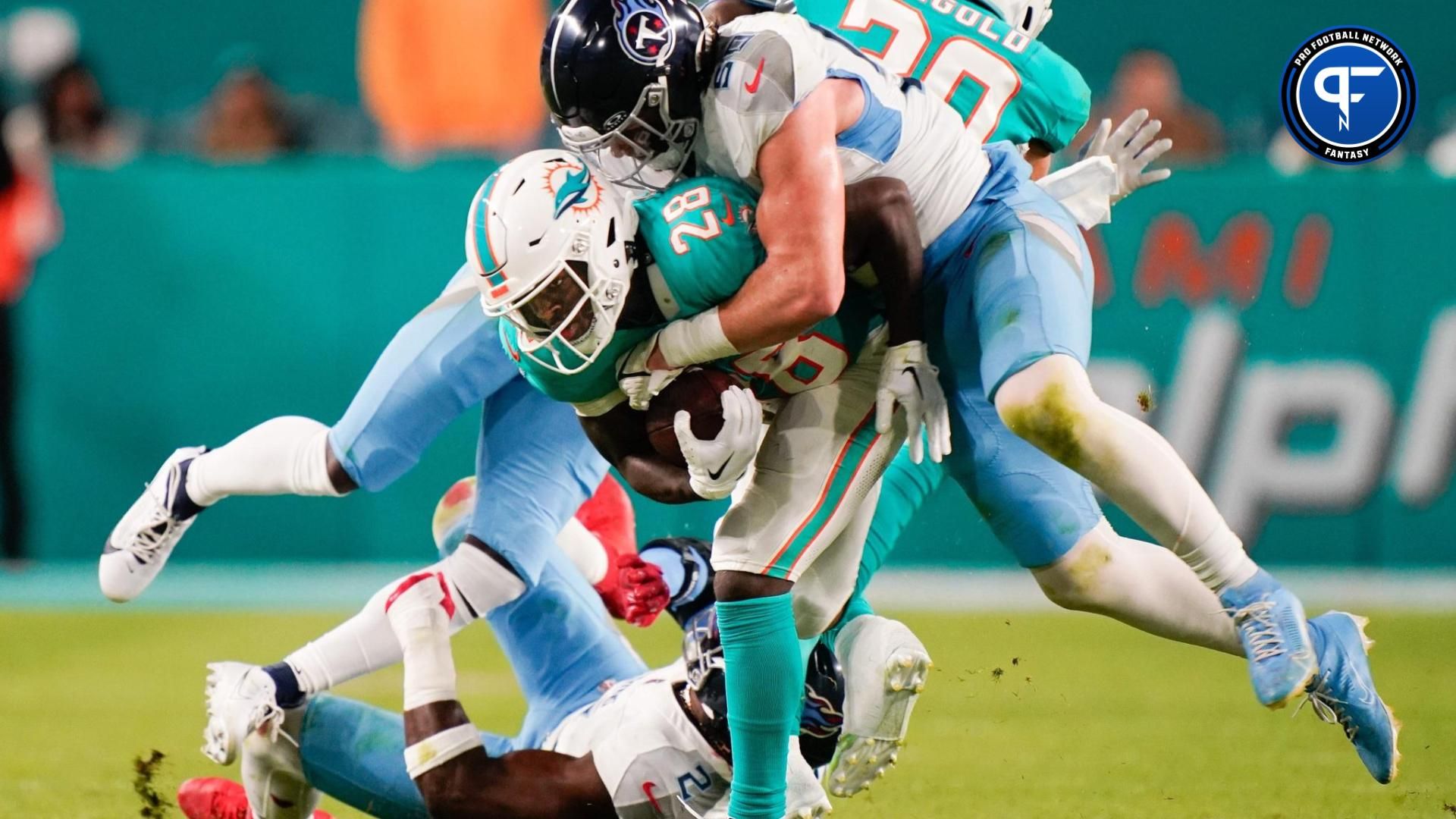 Tennessee Titans linebacker Jack Gibbens (50) leaps on Miami Dolphins running back De'Von Achane (28) during the second quarter at Hard Rock Stadium in Miami, Fla., Monday, Dec. 11, 2023.