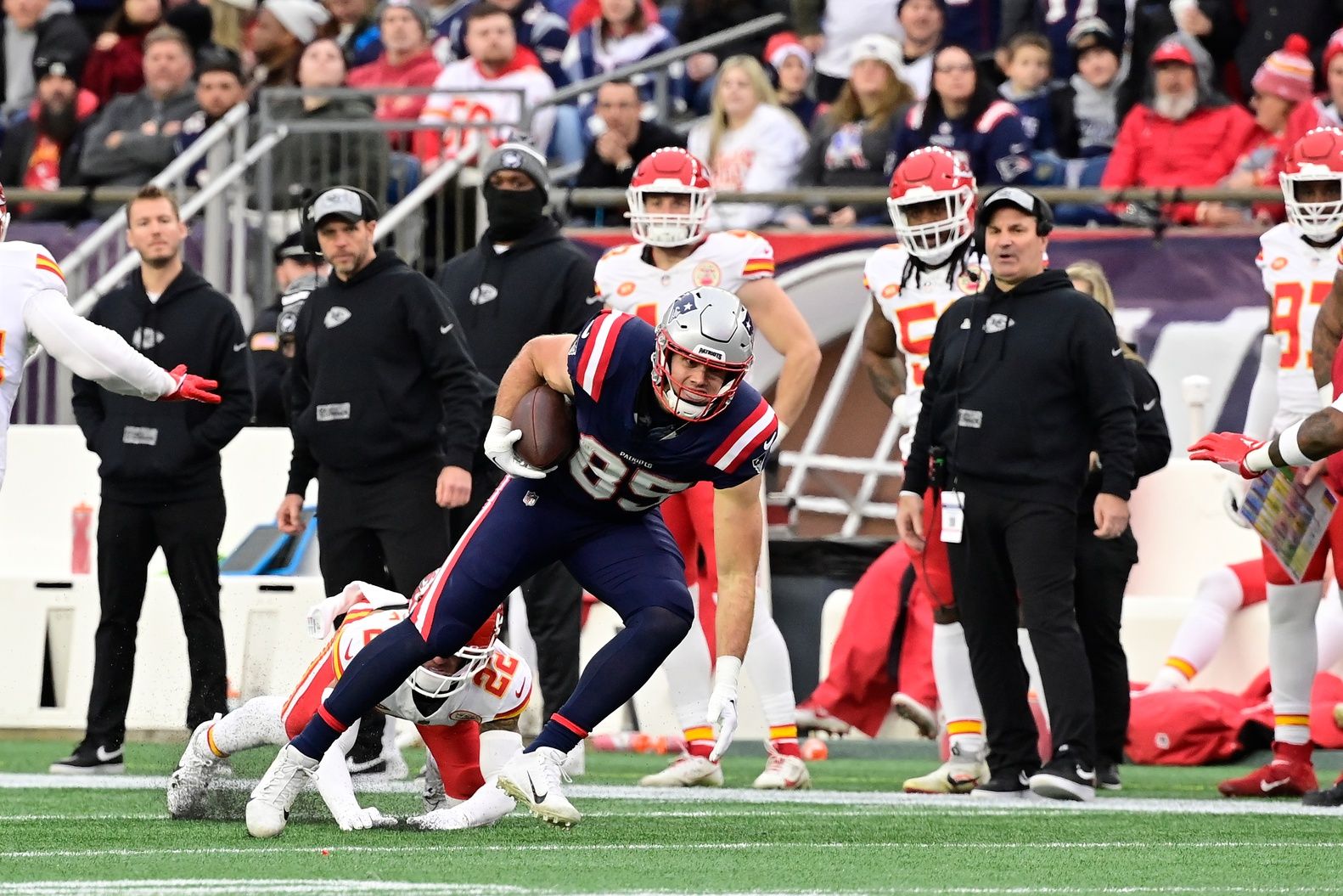 New England Patriots tight end Hunter Henry (85) breaks a tackle by Kansas City Chiefs cornerback Trent McDuffie (22) during the first half at Gillette Stadium.