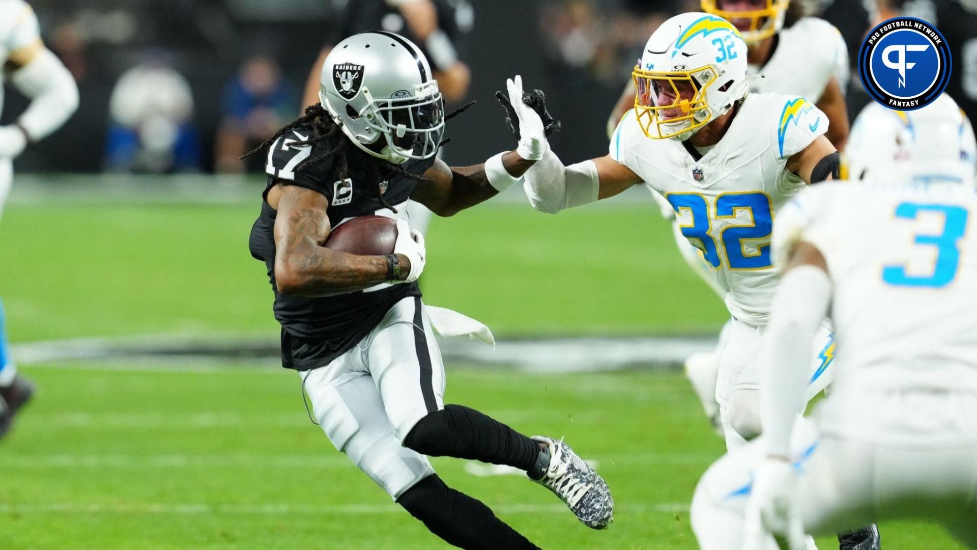 Las Vegas Raiders wide receiver Davante Adams (17) runs against Los Angeles Chargers safety Alohi Gilman (32) in the first quarter at Allegiant Stadium.