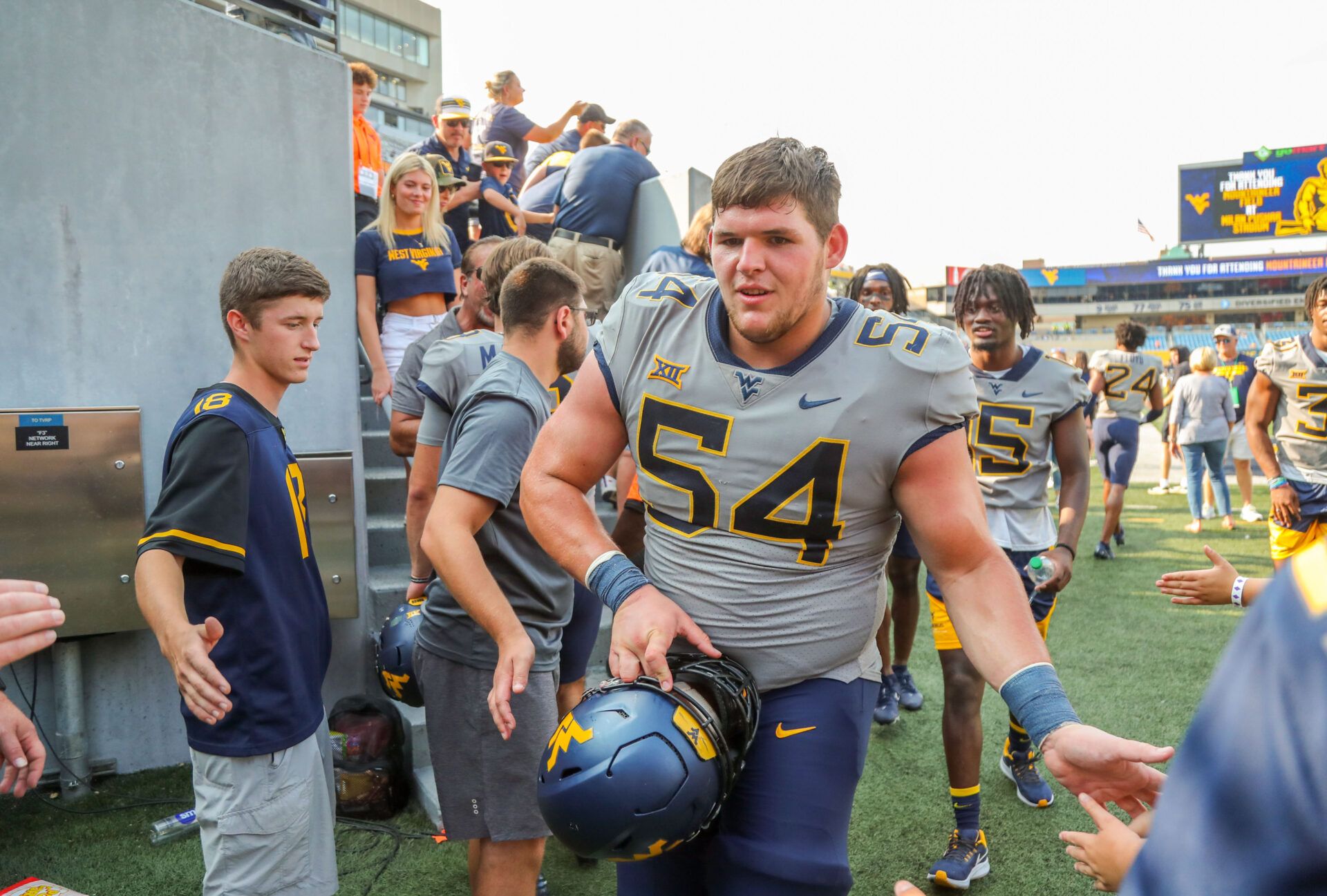 West Virginia Mountaineers offensive lineman Zach Frazier (54) celebrates with fans after defeating the Towson Tigers at Mountaineer Field at Milan Puskar Stadium.