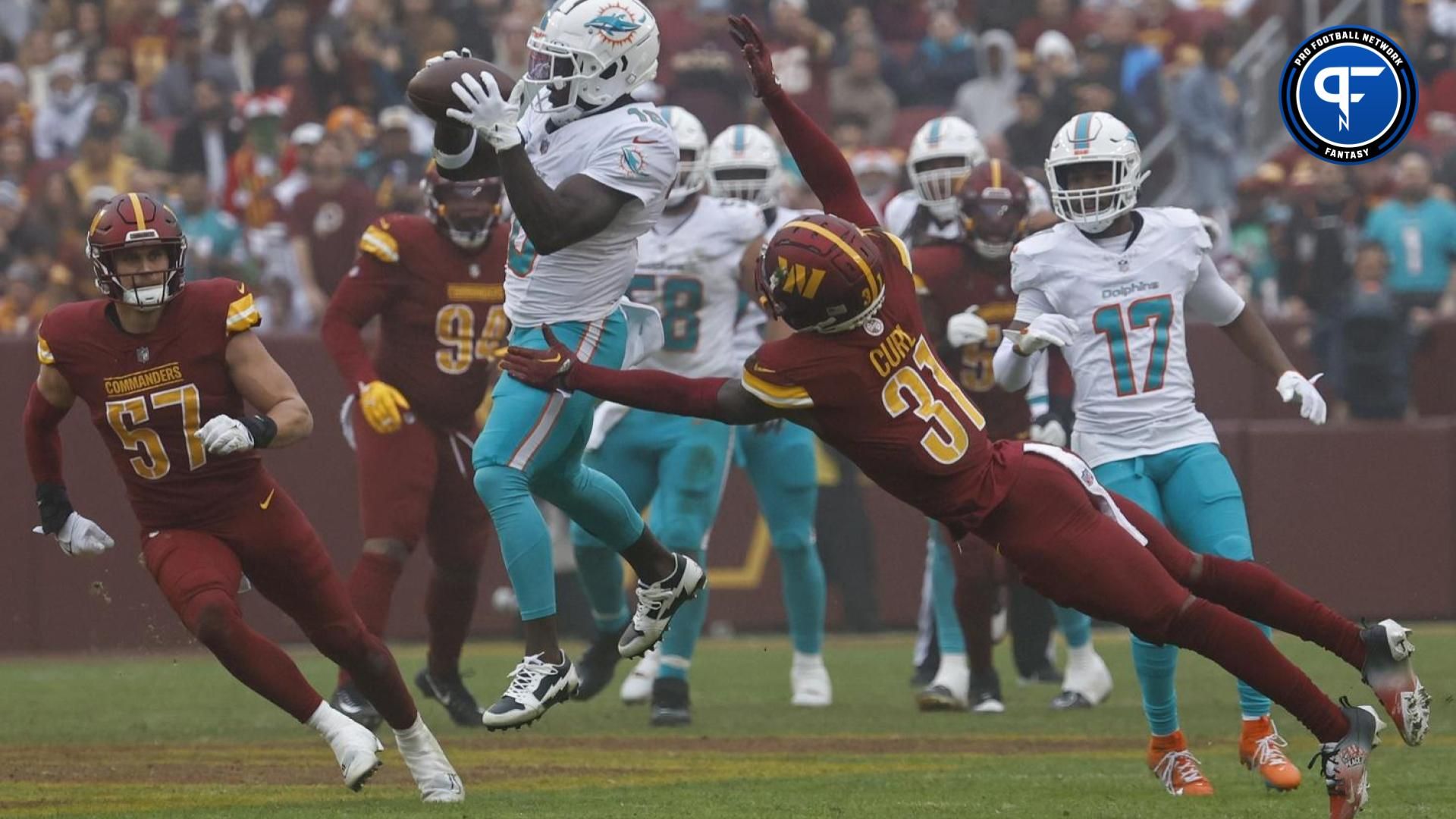 Miami Dolphins wide receiver Tyreek Hill (10) catches a pass as Washington Commanders safety Kamren Curl (31) defends during the second quarter at FedExField