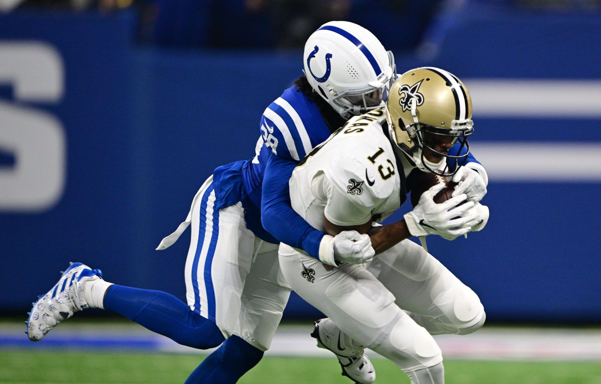 Indianapolis Colts cornerback Tony Brown (38) tackles New Orleans Saints wide receiver Michael Thomas (13) during the first quarter at Lucas Oil Stadium.