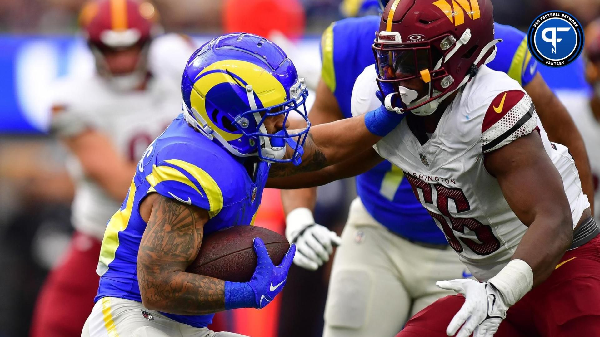 Los Angeles Rams running back Kyren Williams (23) runs the ball against Washington Commanders defensive end KJ Henry (55) during the first half at SoFi Stadium