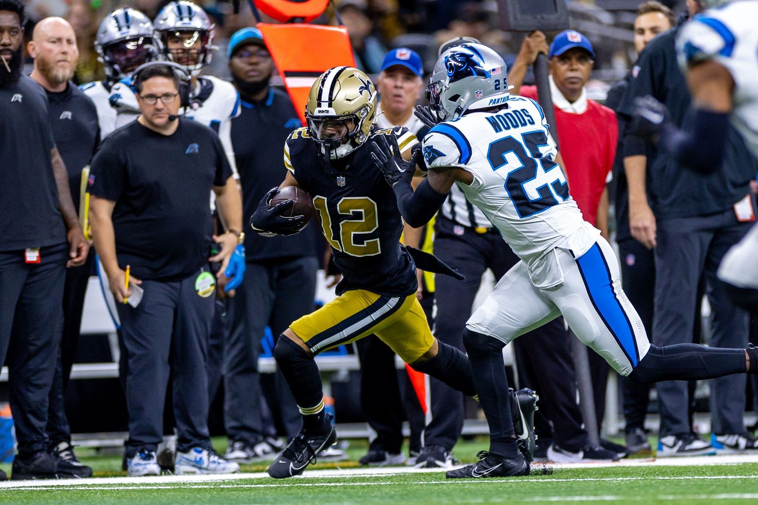 Carolina Panthers safety Xavier Woods (25) pushes New Orleans Saints wide receiver Chris Olave (12) out of bounds on a pass play during the first half at the Caesars Superdome.