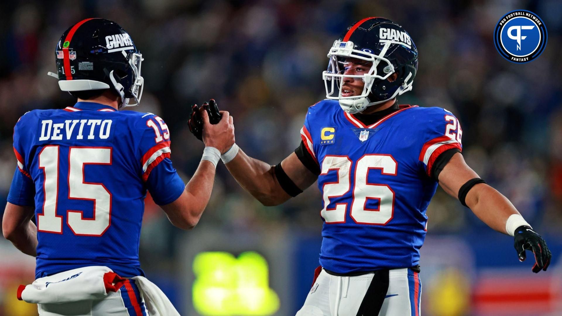 New York Giants running back Saquon Barkley (26) celebrates with quarterback Tommy DeVito (15) after scoring a touchdown during the third quarter against the Green Bay Packers at MetLife Stadium.