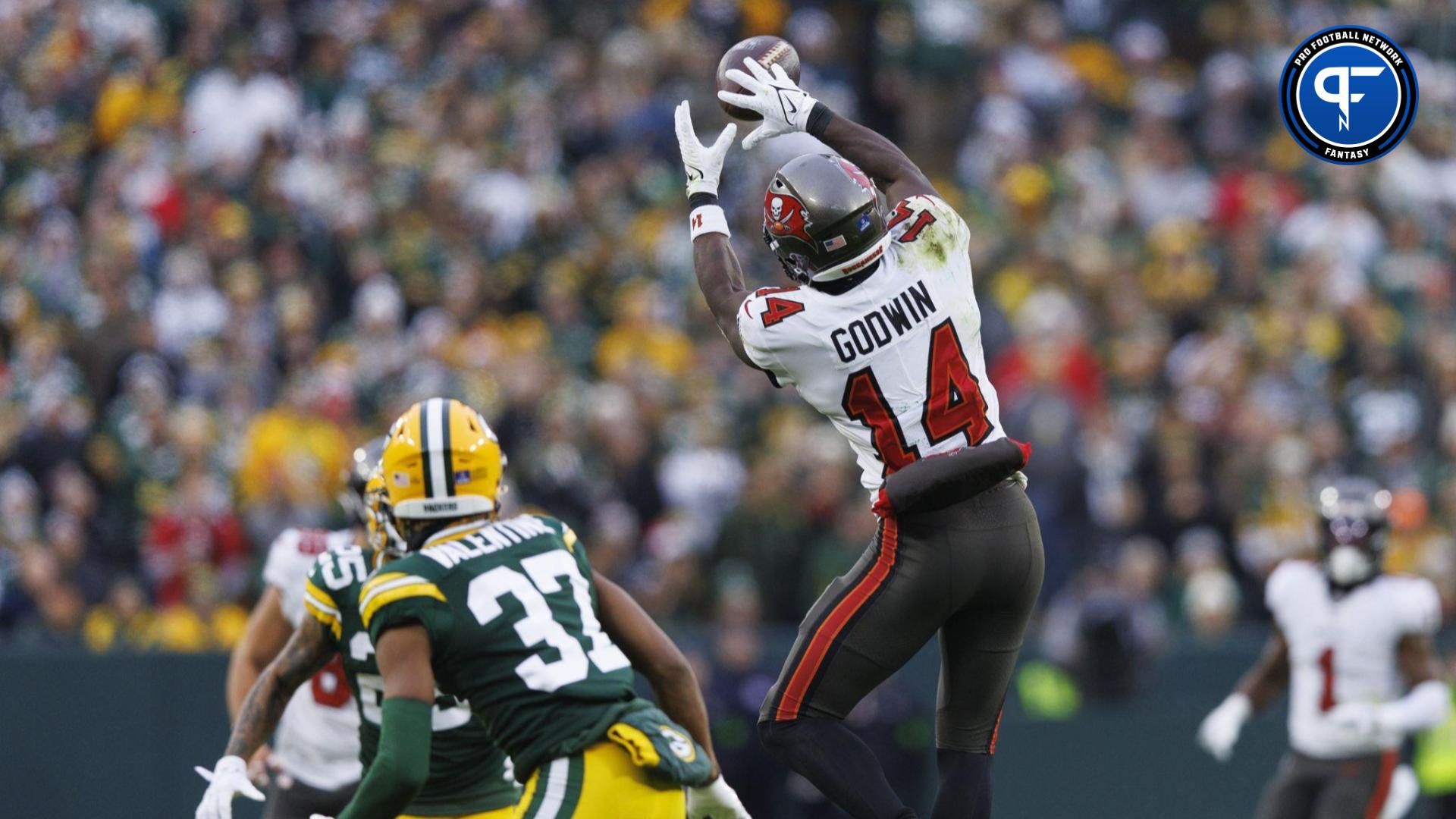 ampa Bay Buccaneers wide receiver Chris Godwin (14) leaps to catch a pass in front of Green Bay Packers cornerback Carrington Valentine (37) during the second quarter at Lambeau Field.