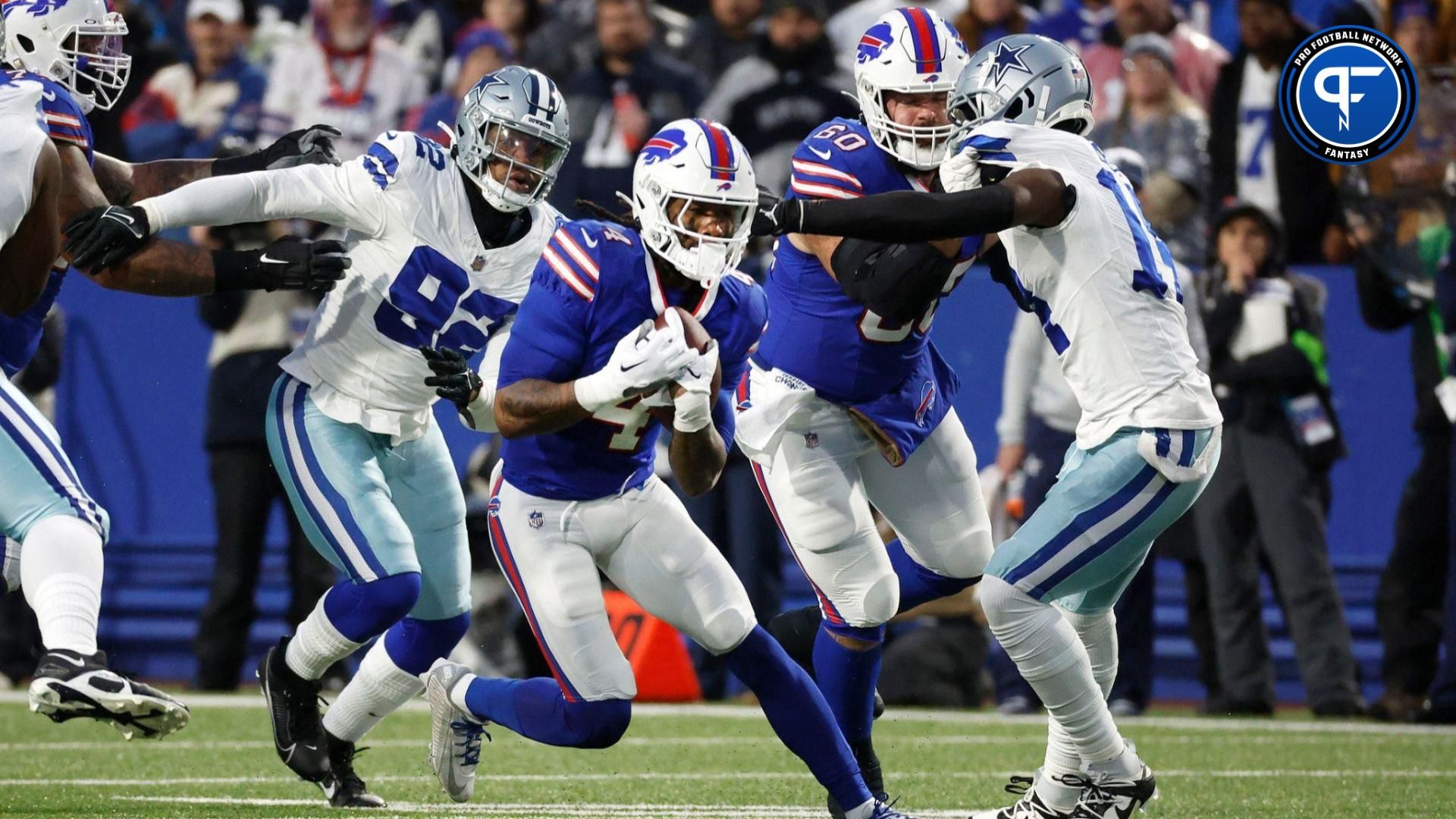 Buffalo Bills running back James Cook (4) runs through a hole at the line of scrimmage.