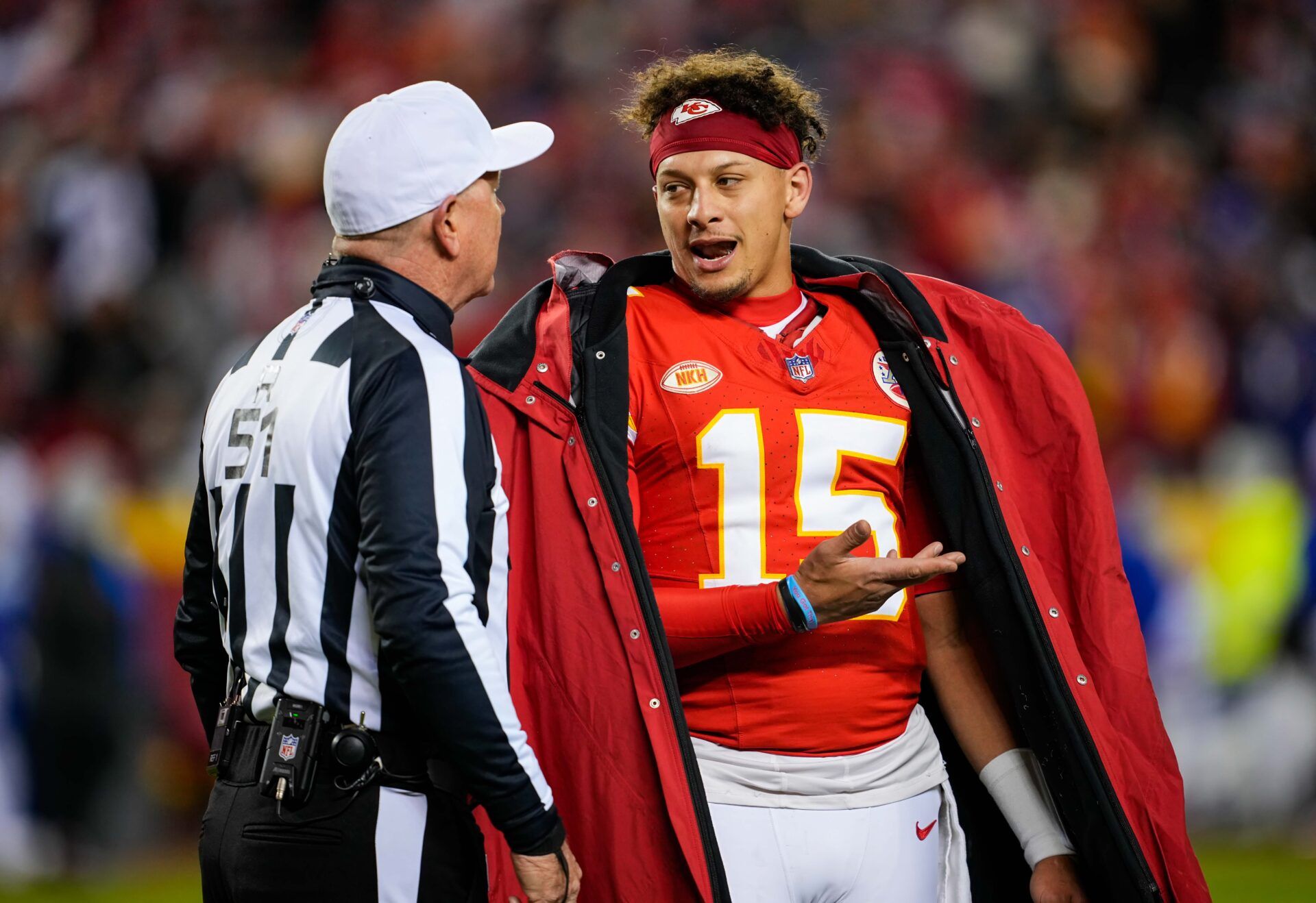 Kansas City Chiefs quarterback Patrick Mahomes (15) talks with referee Carl Cheffers (51) after penalty during the second half against the Buffalo Bills at GEHA Field at Arrowhead Stadium.