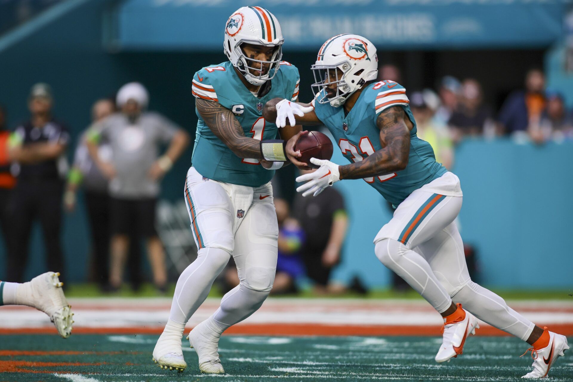 Miami Dolphins quarterback Tua Tagovailoa (1) gives the ball to running back Raheem Mostert (31) against the Dallas Cowboys during the first quarter at Hard Rock Stadium.