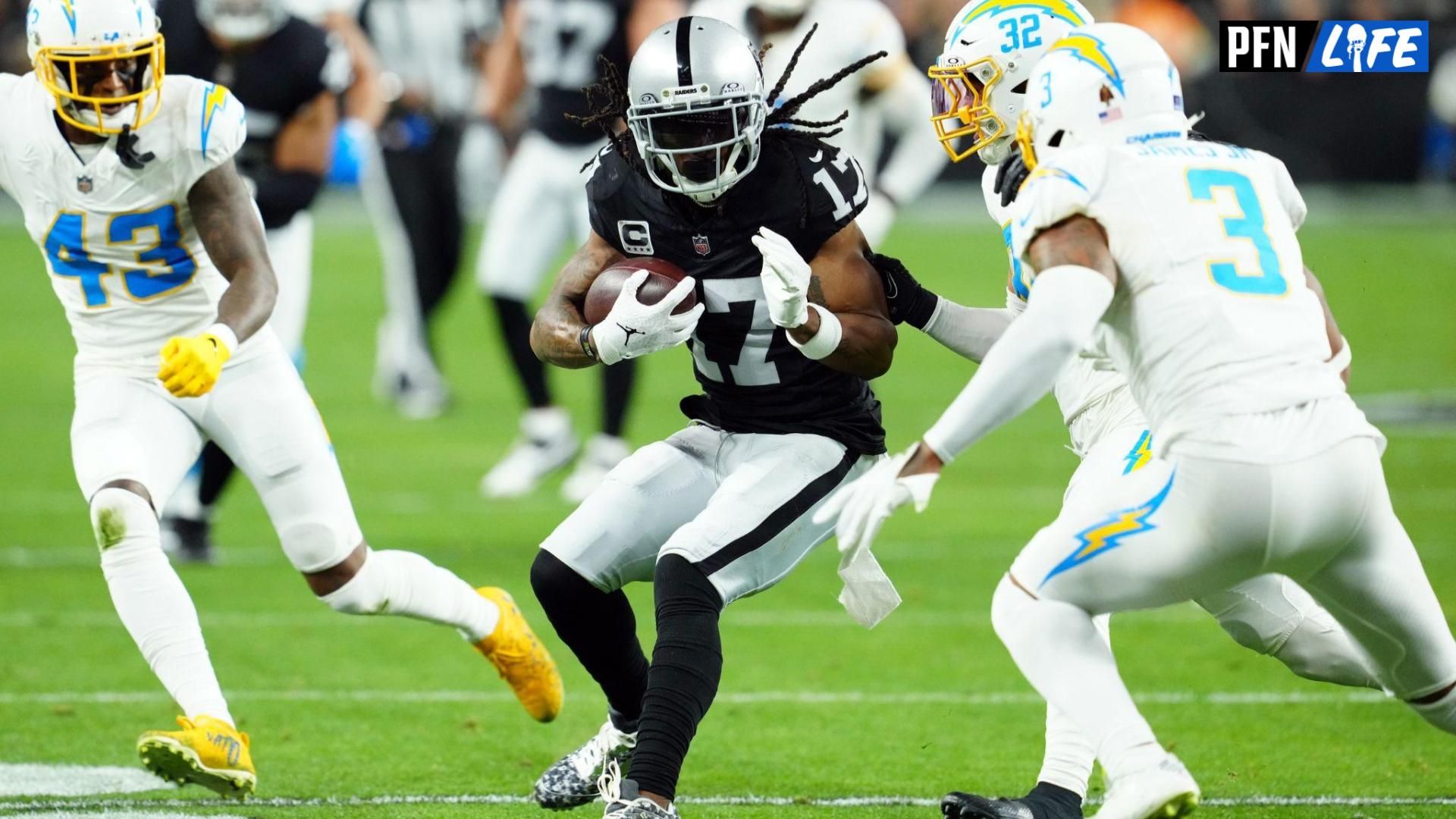 Las Vegas Raiders wide receiver Davante Adams (17) runs against Los Angeles Chargers safety Alohi Gilman (32) and safety Derwin James Jr. (3) in the first quarter at Allegiant Stadium.