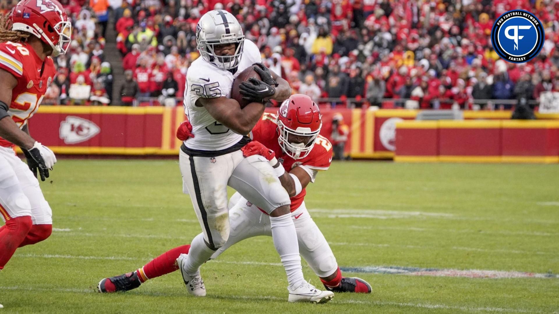 Las Vegas Raiders running back Zamir White (35) runs the ball as Kansas City Chiefs safety Mike Edwards (21) makes the tackle during the second half at GEHA Field at Arrowhead Stadium.