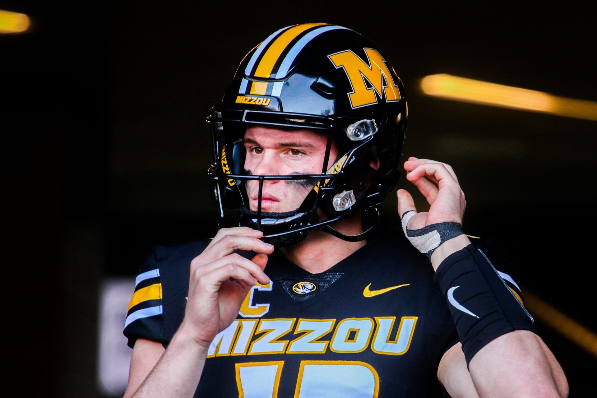 Missouri quarterback Brady Cook snaps on his helmet before the Tigers defeated Tennessee.