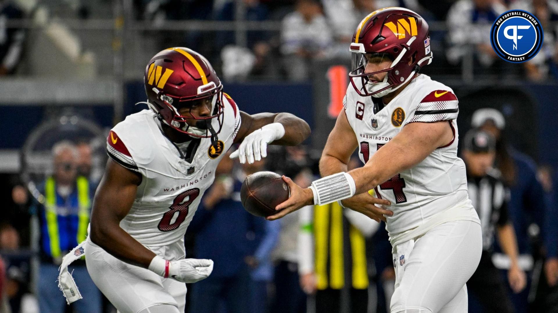 Washington Commanders running back Brian Robinson Jr. (8) and quarterback Sam Howell (14) in action during the game between the Dallas Cowboys and the Washington Commanders at AT&T Stadium.