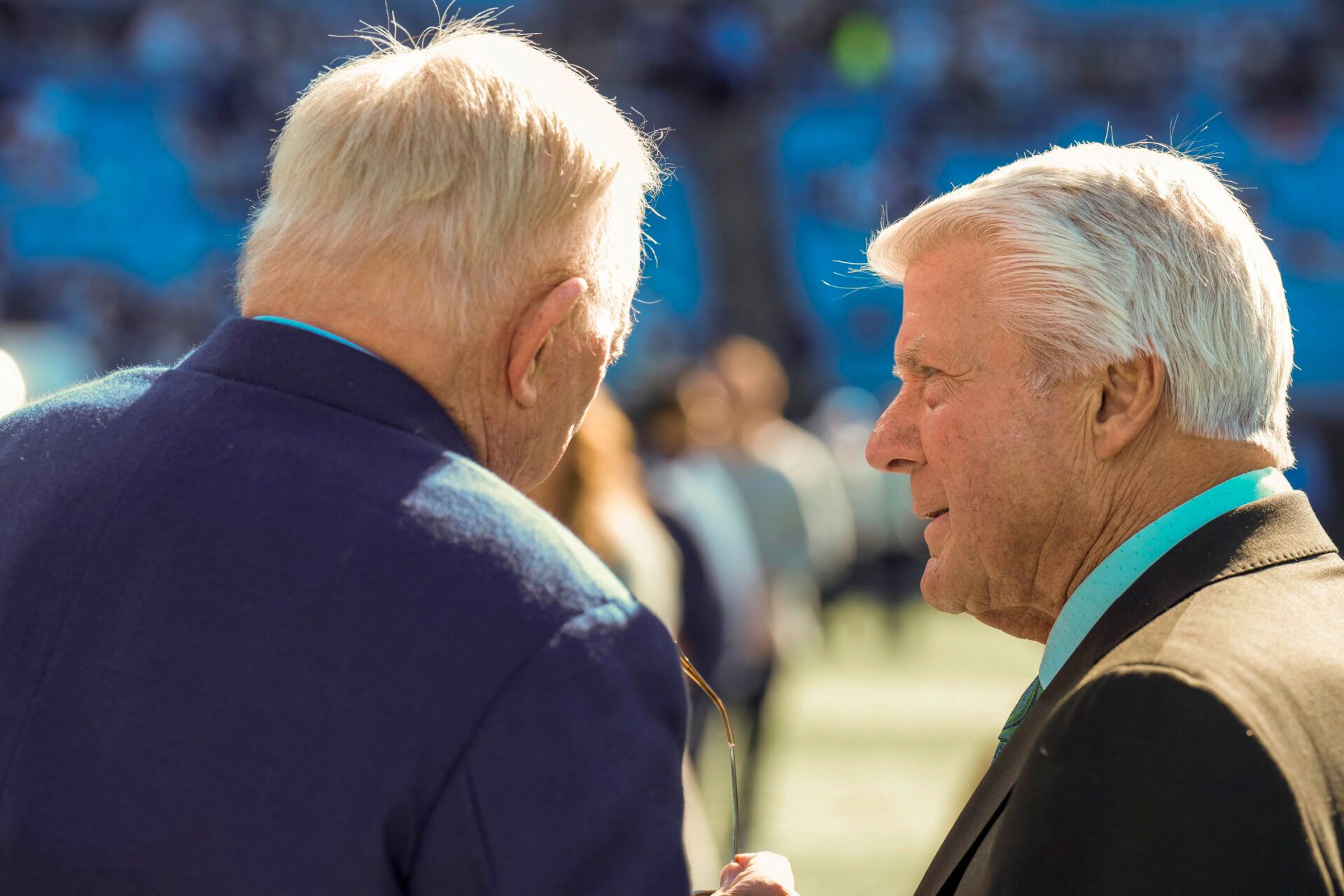 Cowboys owner Jerry Jones chats with announcer and former coach Jimmie Johnson during pregame warm ups at Bank of America Stadium.