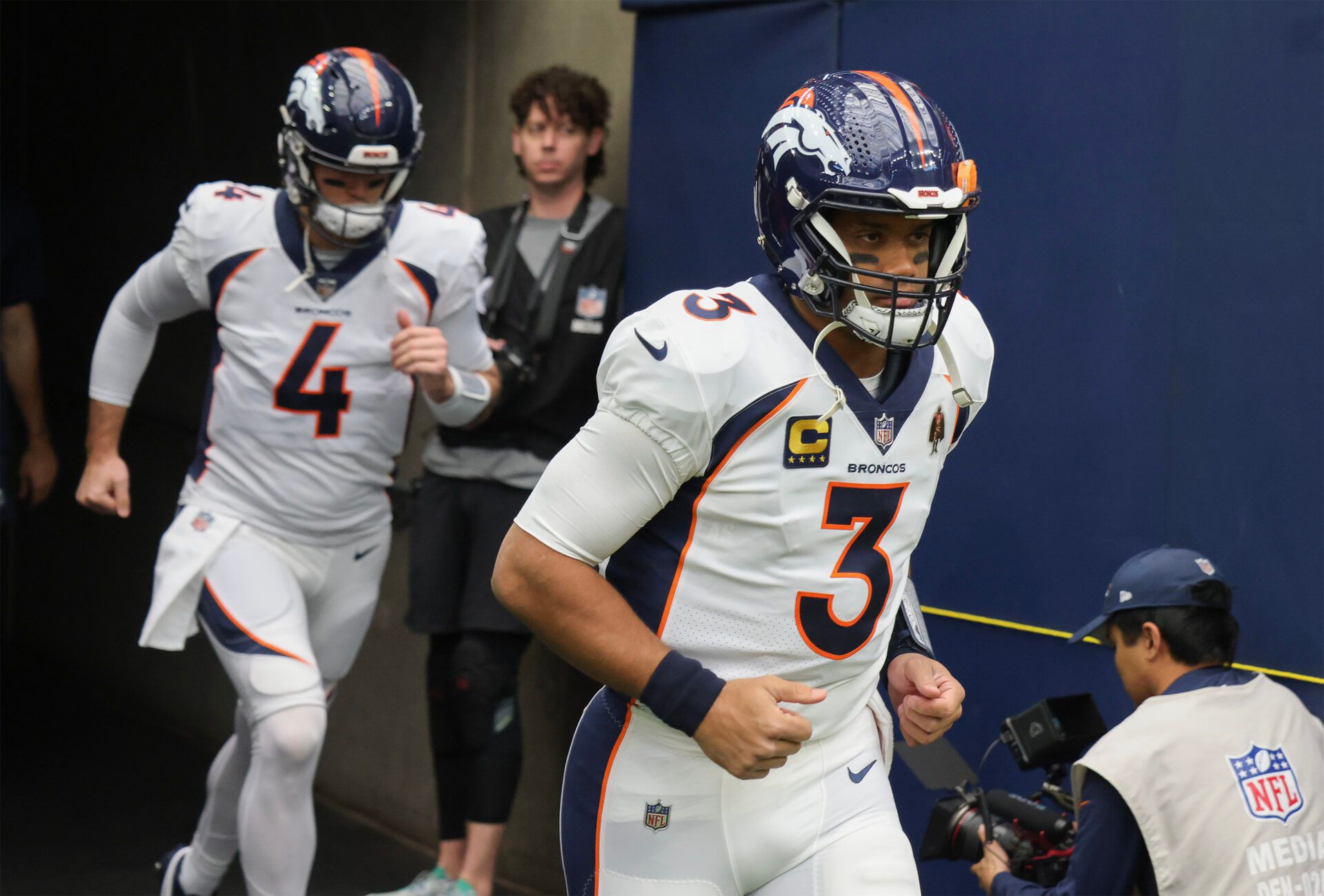 Denver Broncos quarterback Russell Wilson (3) and quarterback Jarrett Stidham (4) run out on the field before playing against the Houston Texans at NRG Stadium.