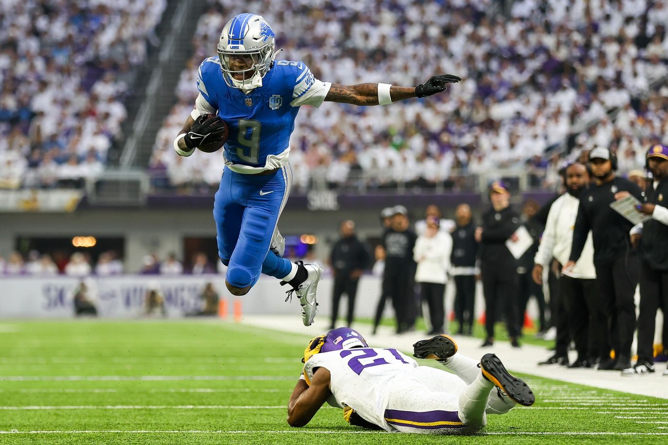 Detroit Lions wide receiver Jameson Williams (9) breaks a tackle by Minnesota Vikings cornerback Akayleb Evans (21) during the first quarter at U.S. Bank Stadium.